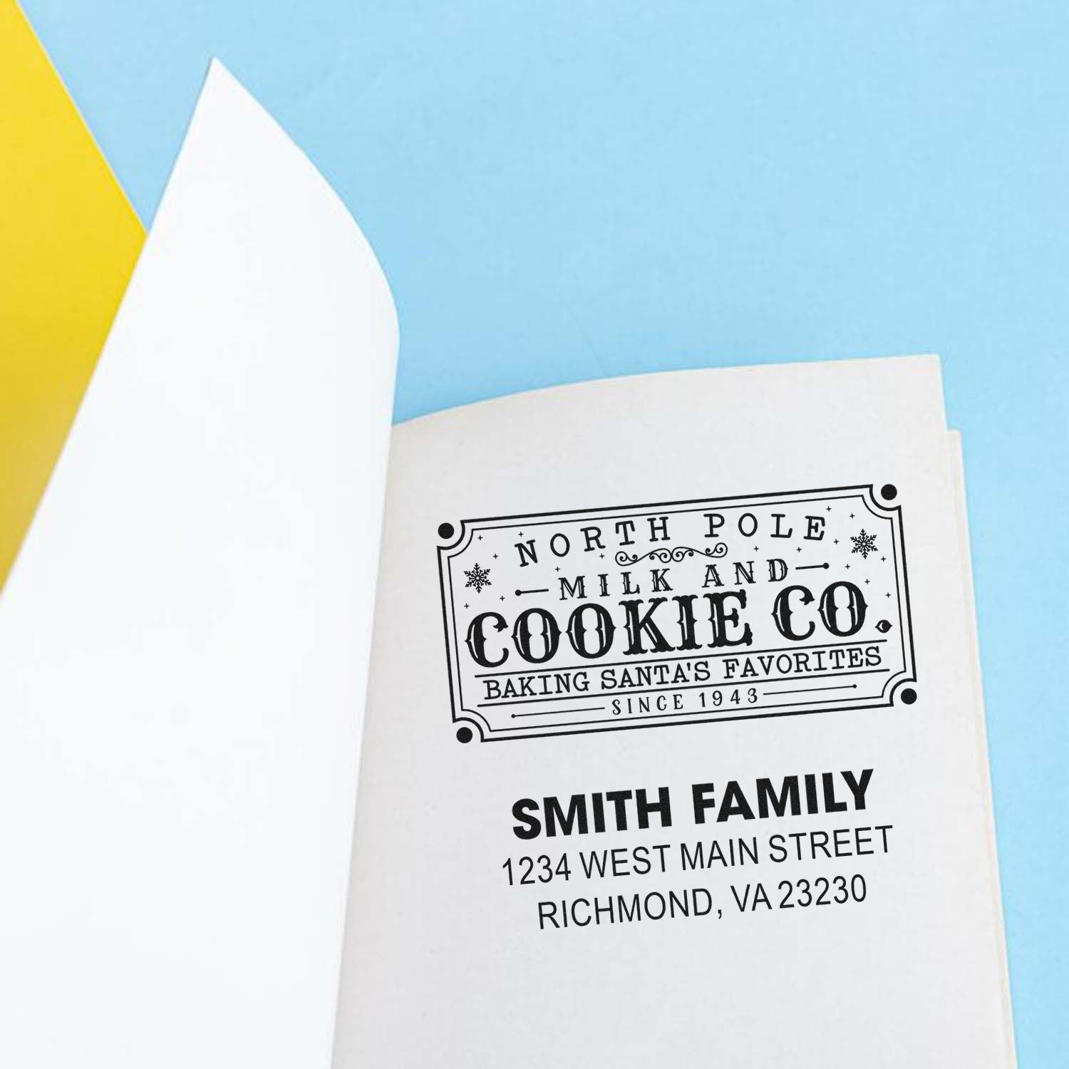 Custom holiday rubber stamp with North Pole Milk and Cookie Co. design and Smith Family return address on paper.