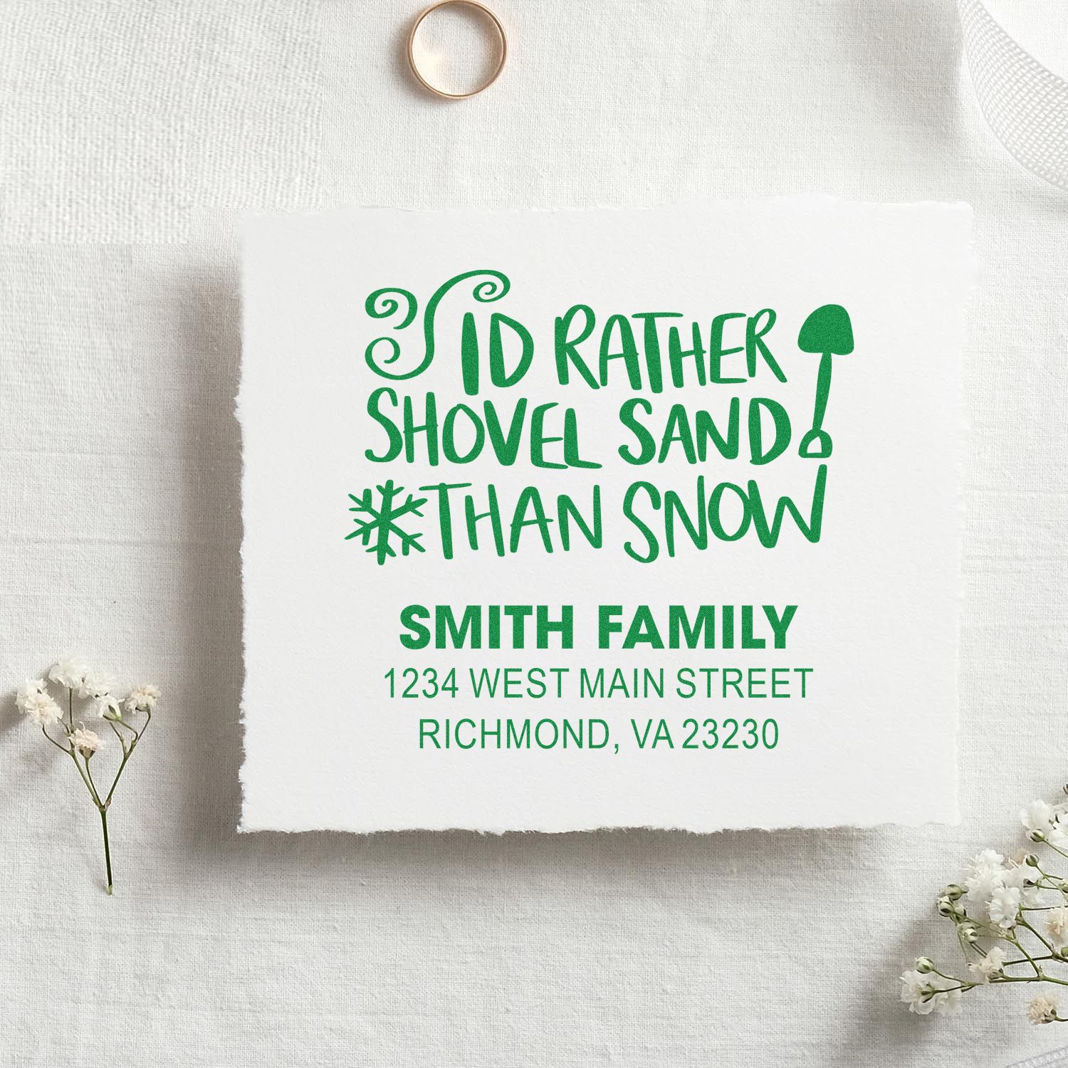 Personalized rubber stamp with holiday phrase Id rather shovel sand than snow and Smith family return address.