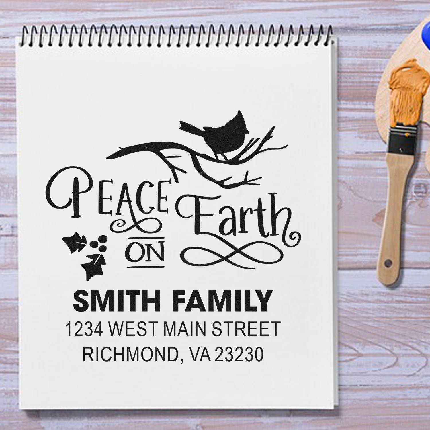 Custom rubber stamp on notebook with Peace on Earth design, Smith Family name, and return address for holiday mail.