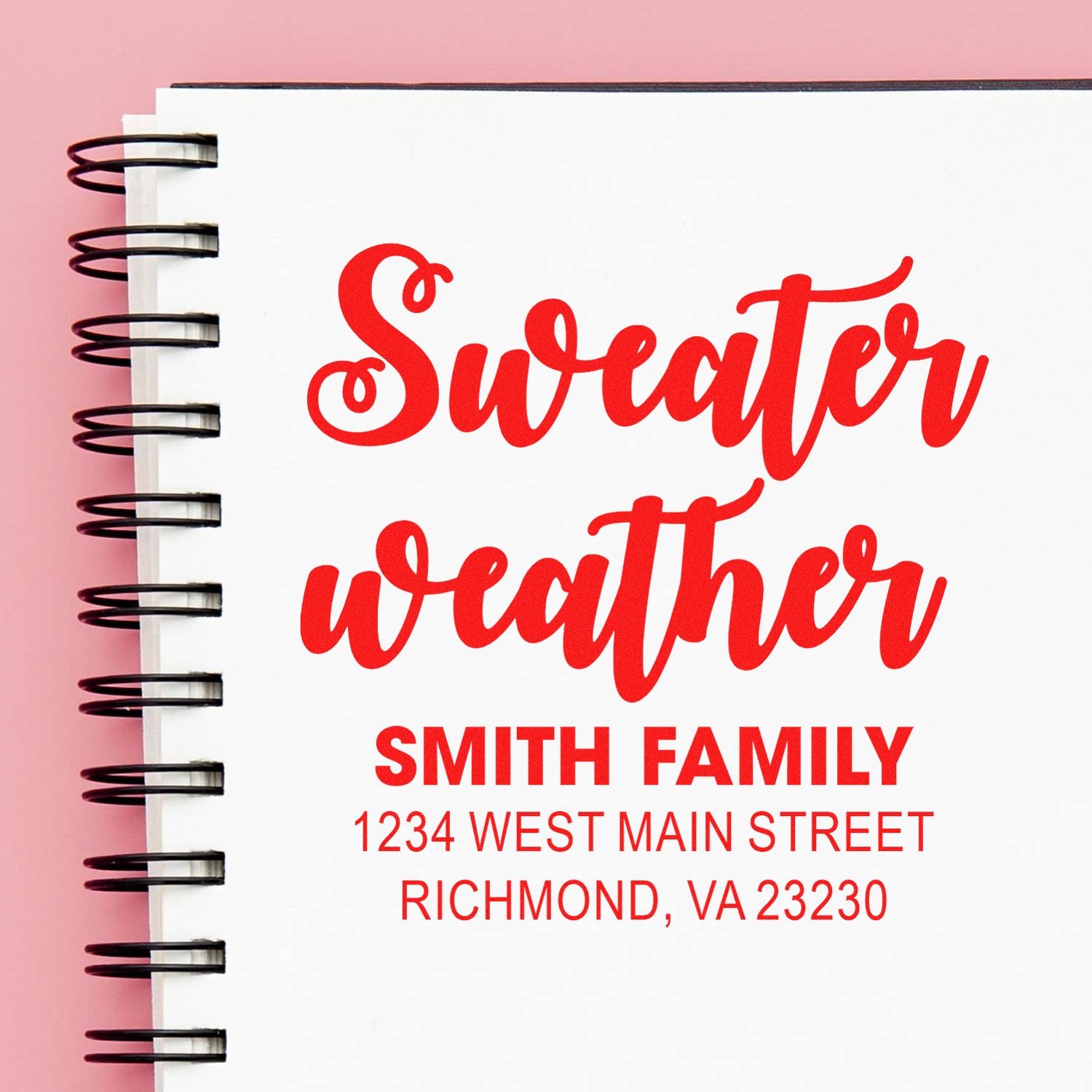 Custom rubber stamp with Sweater Weather design and Smith Family return address, red ink on notebook.