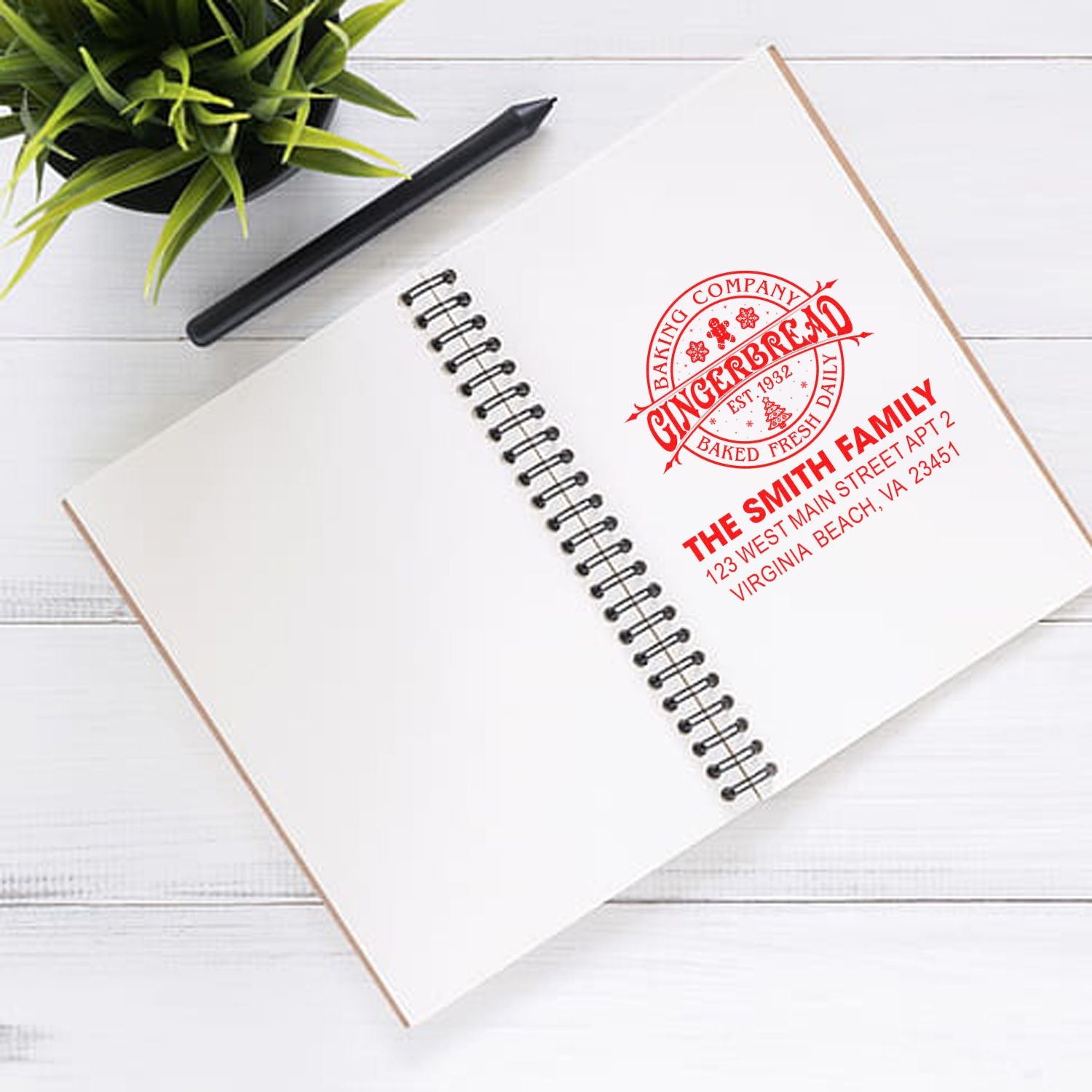 Custom rubber stamp on notebook for bakery branding with family name and address design
