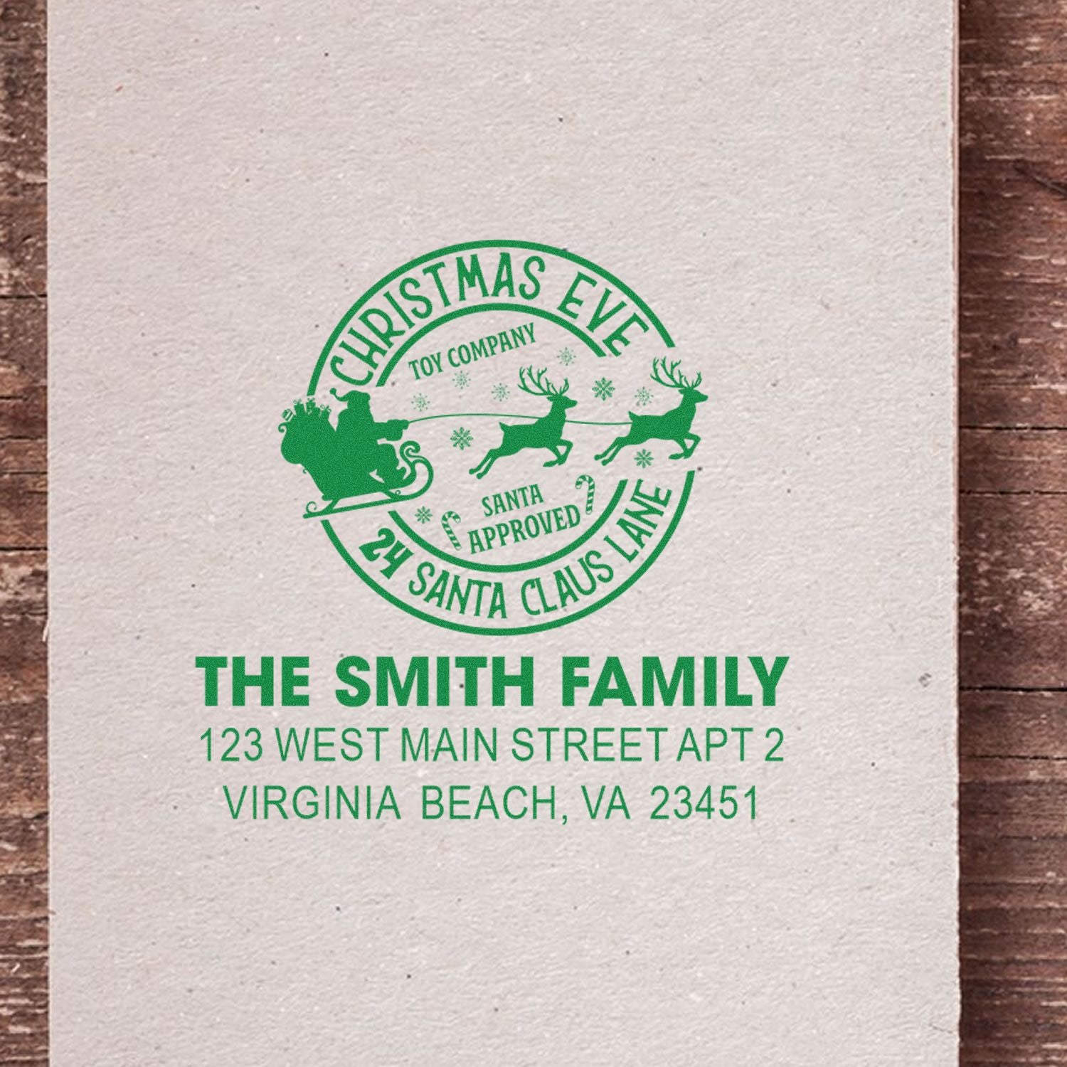 Personalized Christmas return address rubber stamp with Santa sleigh design and family mailing address.