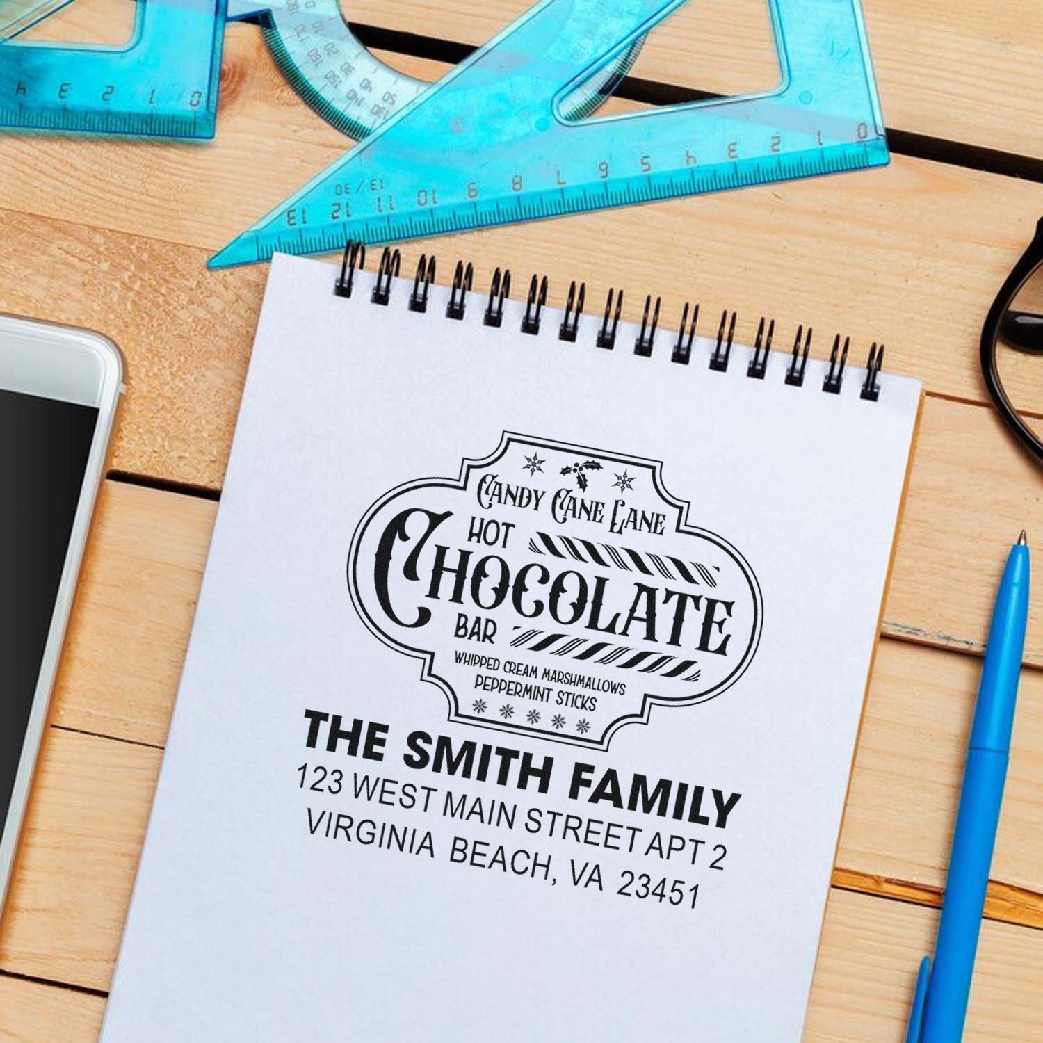 Custom return address rubber stamp imprint on notebook, featuring The Smith Family holiday hot chocolate bar design.