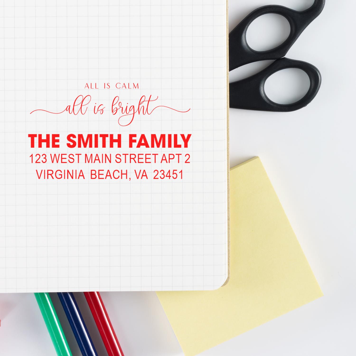 Custom return address rubber stamp for The Smith Family on stationery, with scissors and pens for personalized mailing.