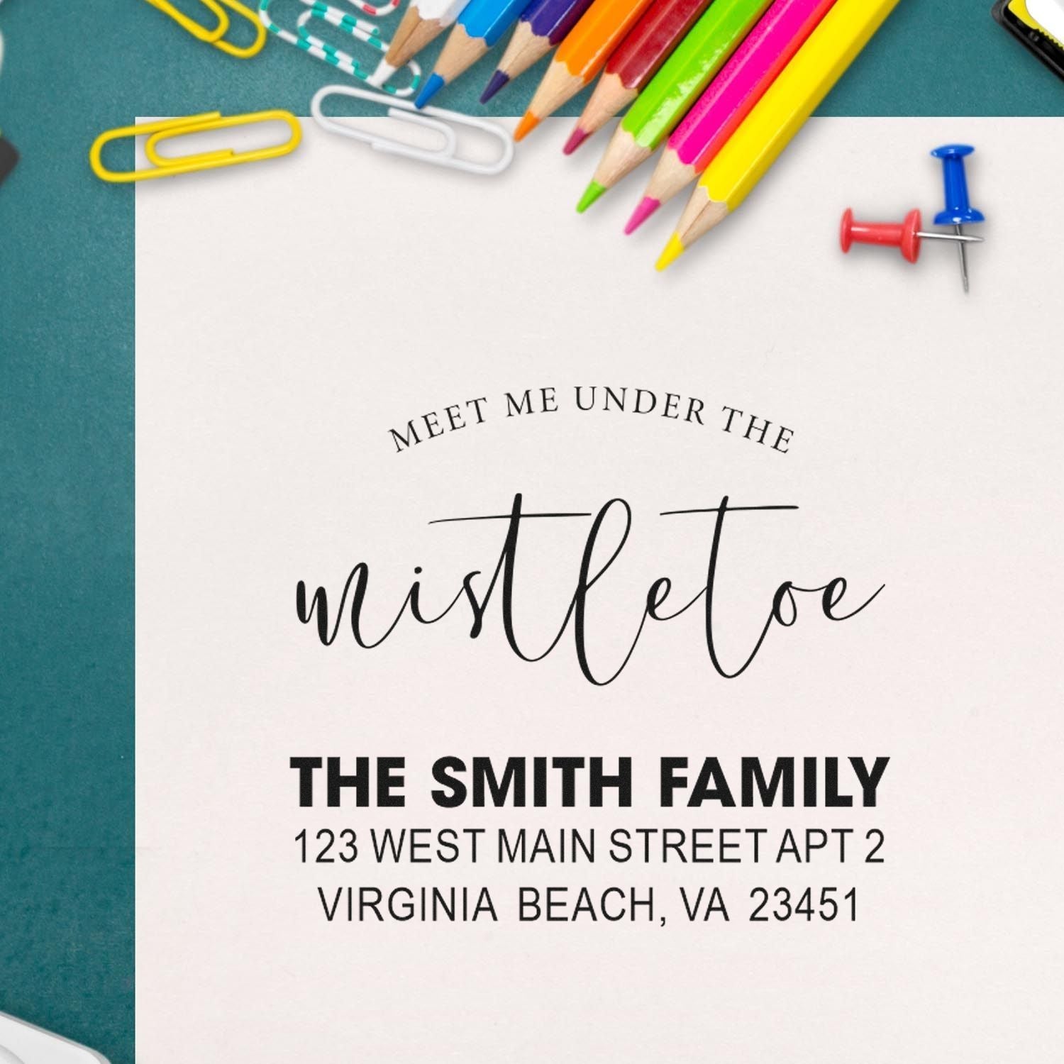 Personalized custom rubber stamp sample with Meet Me Under the Mistletoe and The Smith Family return address for holiday cards.