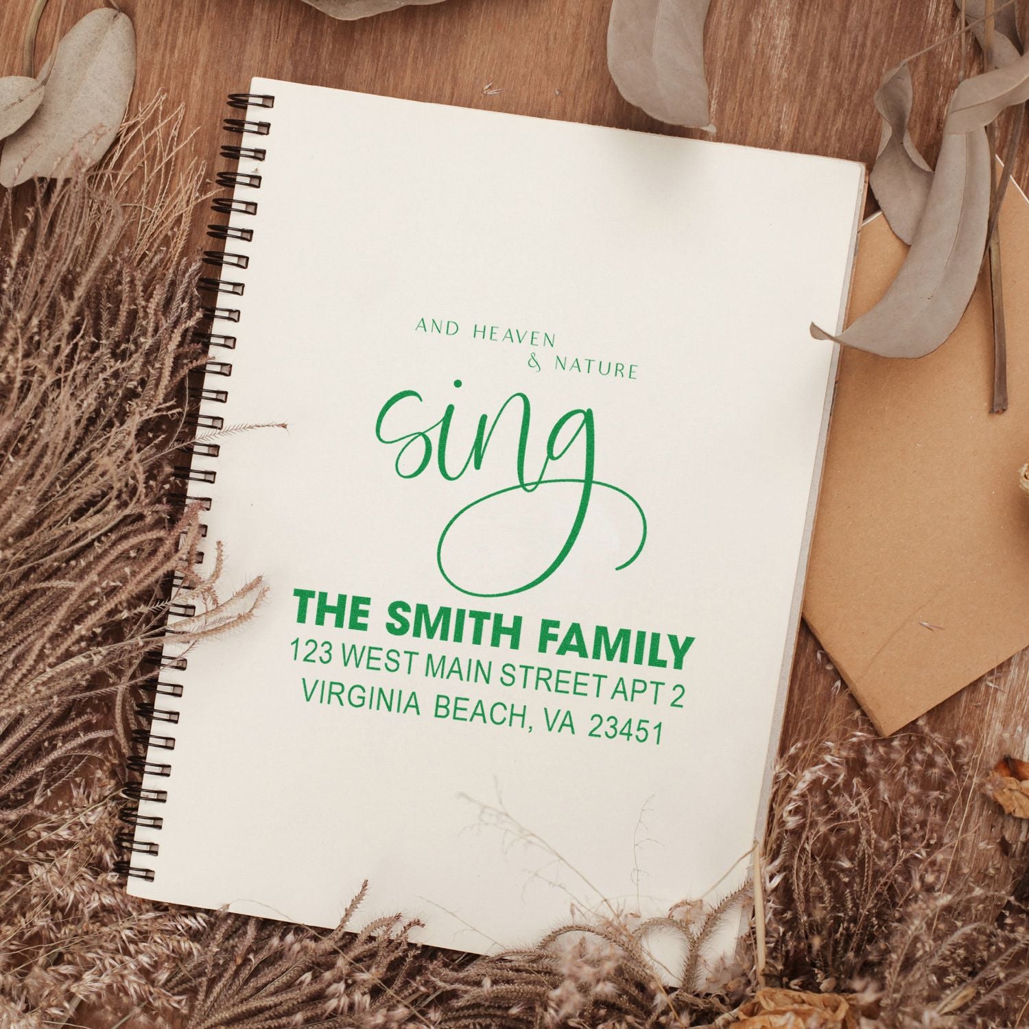 Personalized family address rubber stamp with The Smith Family return address on a notebook, styled with natural decor.