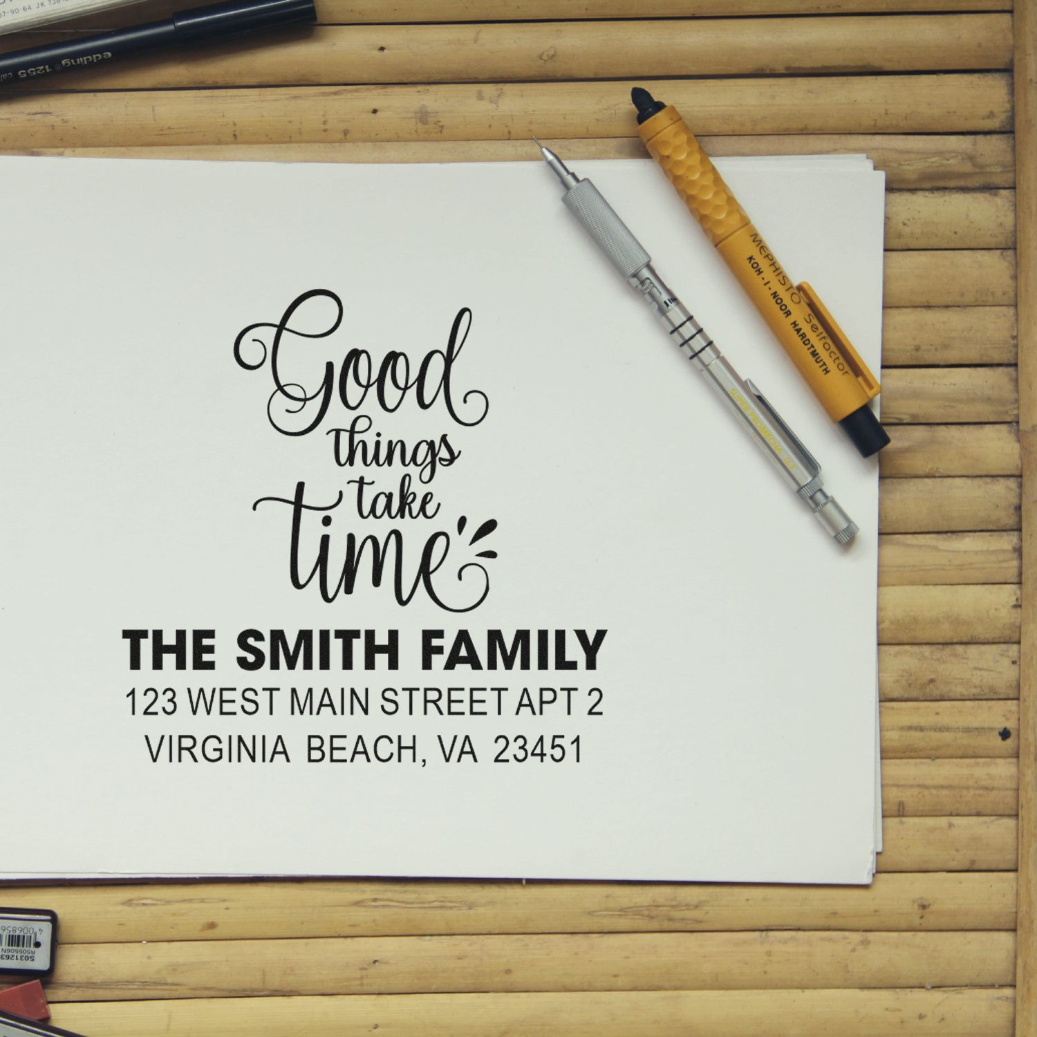 Custom rubber stamp design with Good things take time calligraphy and Smith family address stamp on paper.