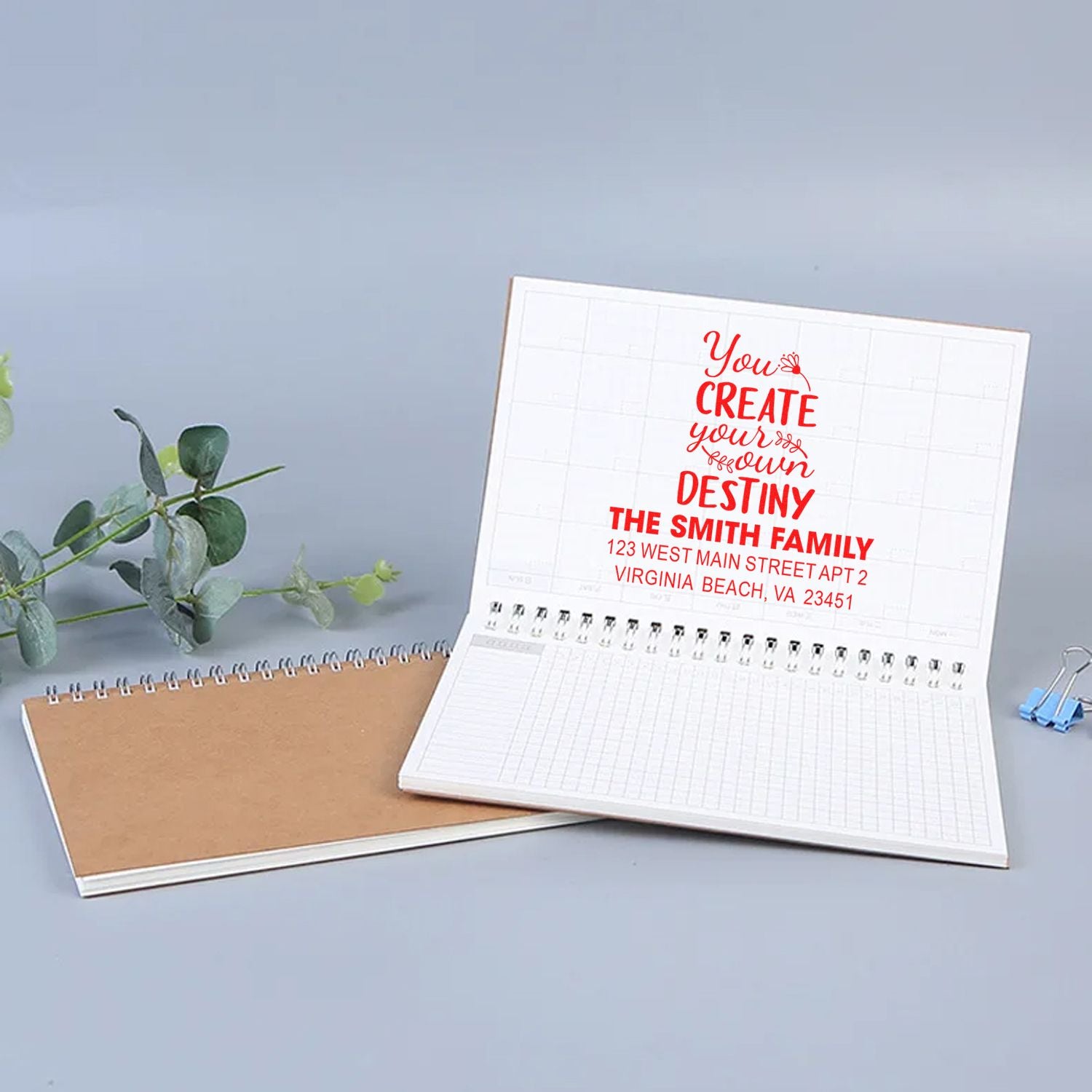 Personalized return address rubber stamp imprint in an open notebook, featuring family name and motivational quote.