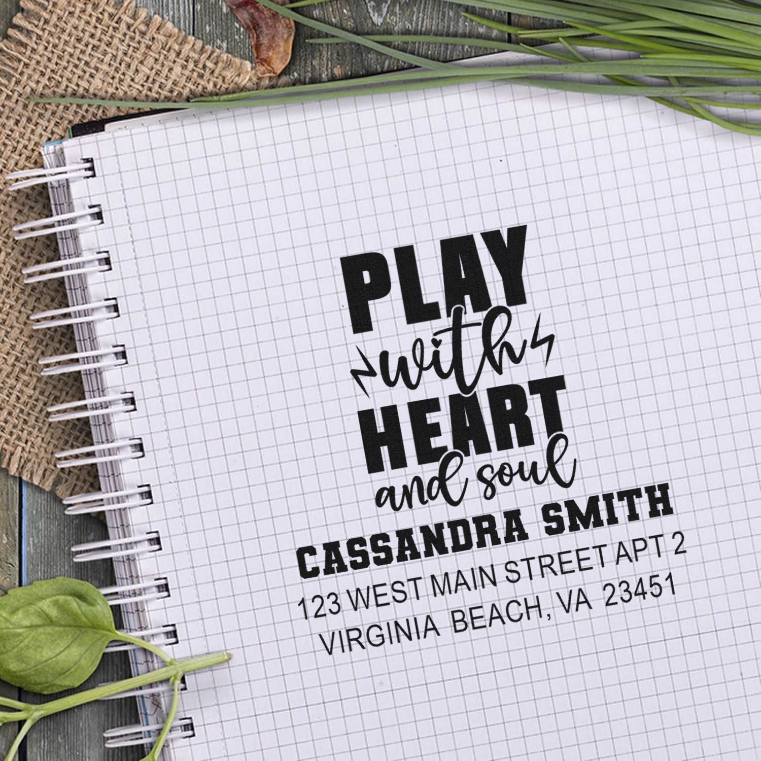 Personalized rubber stamp impression reading Play with heart and soul with name and return address on notebook paper.