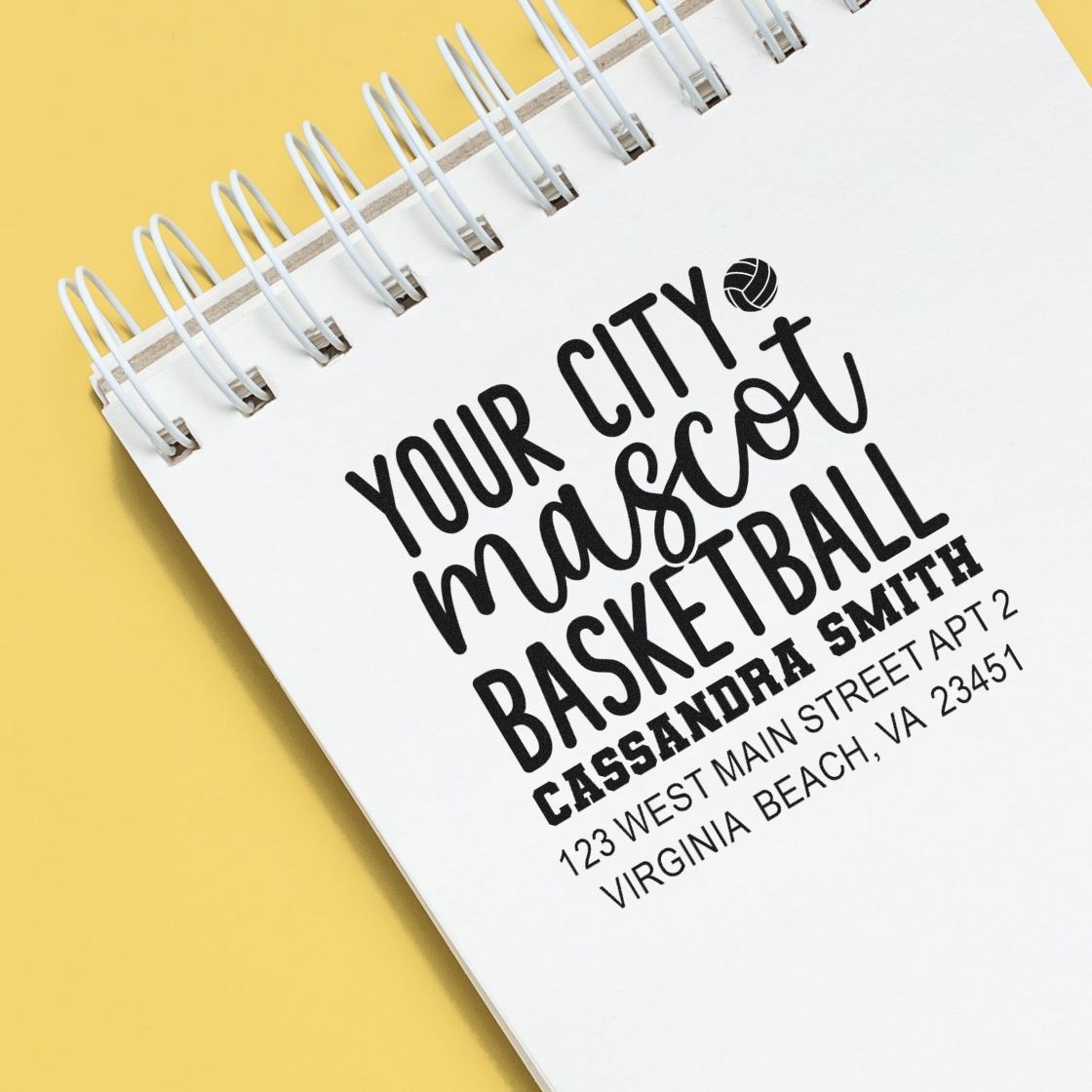 Custom basketball rubber stamp design with city mascot, name, and address on a notebook cover.