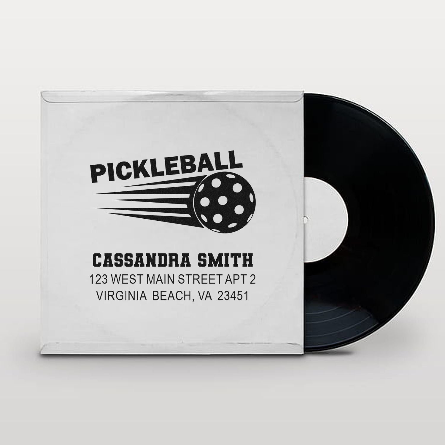 Custom pickleball address rubber stamp mockup with personalized name and address on vinyl record sleeve packaging.