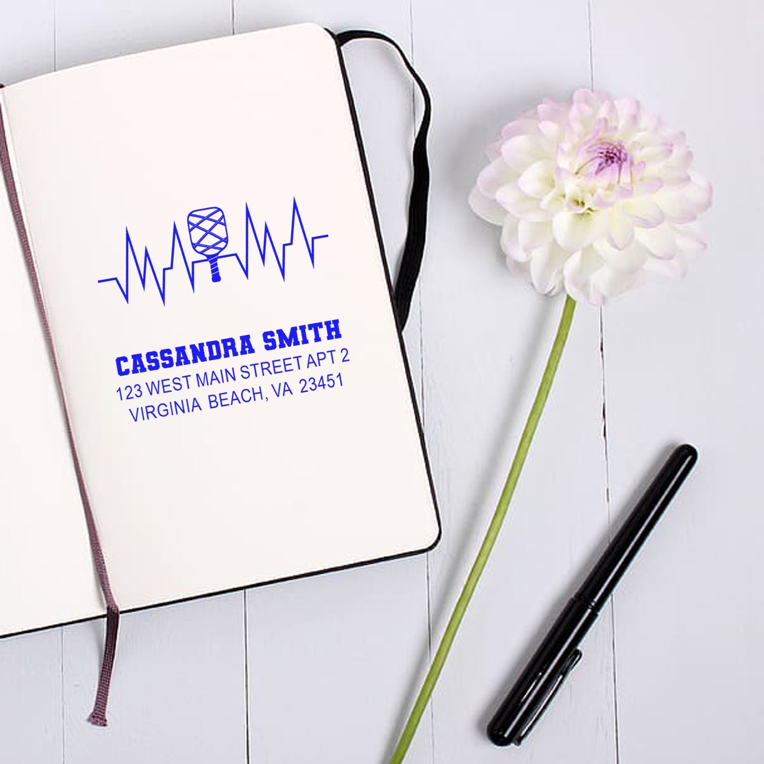 Custom rubber address stamp with name, address and microphone design, shown on a notebook for personalized stationery.