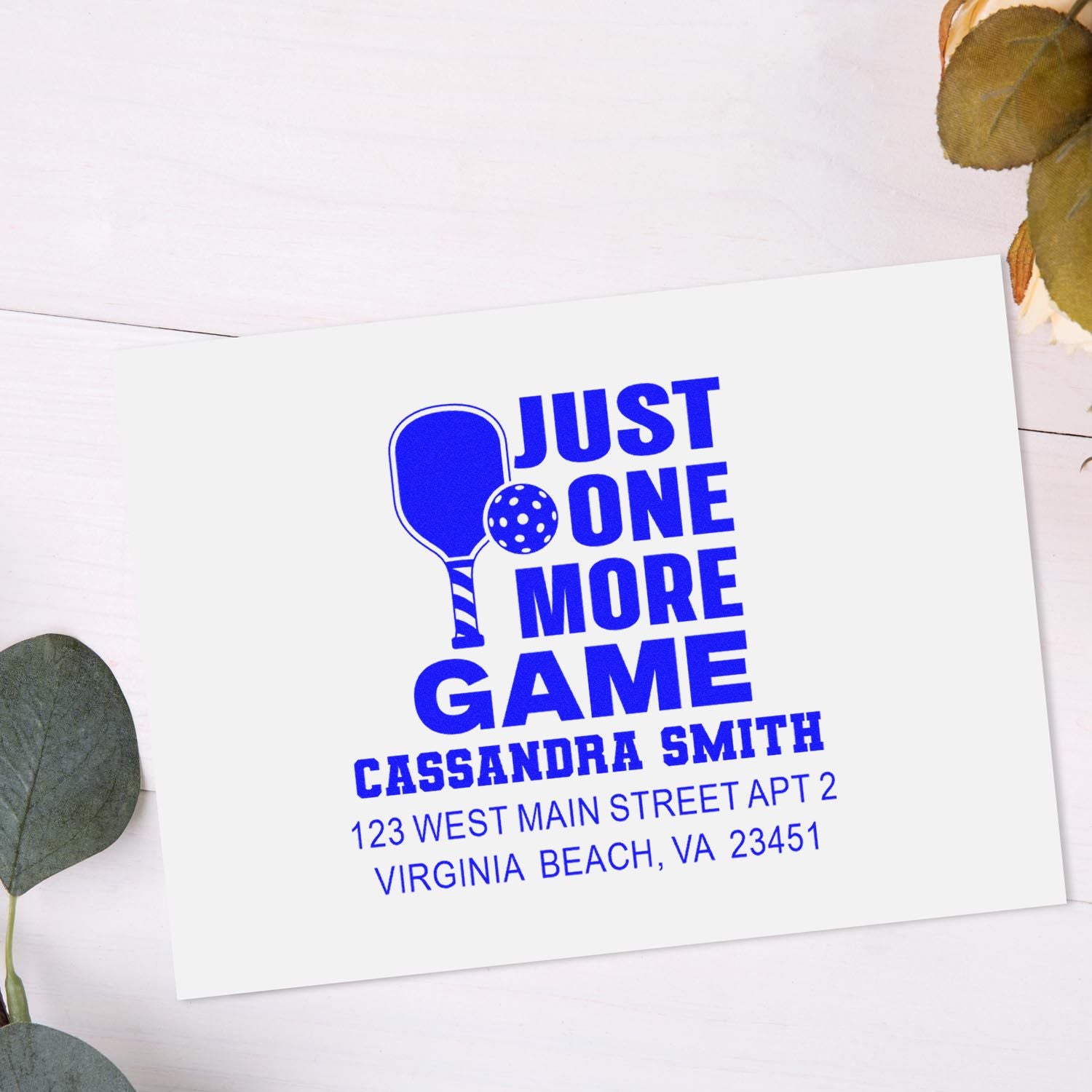 Pickleball-themed custom return address rubber stamp for envelopes, featuring Just One More Game in bold blue ink.