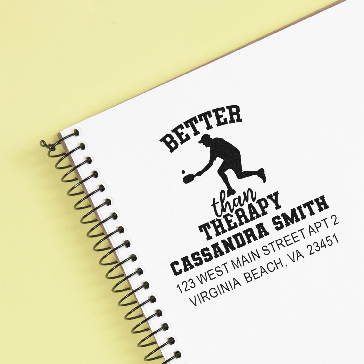 Custom rubber stamp imprint on spiral notebook featuring Better Than Therapy pickleball address design.