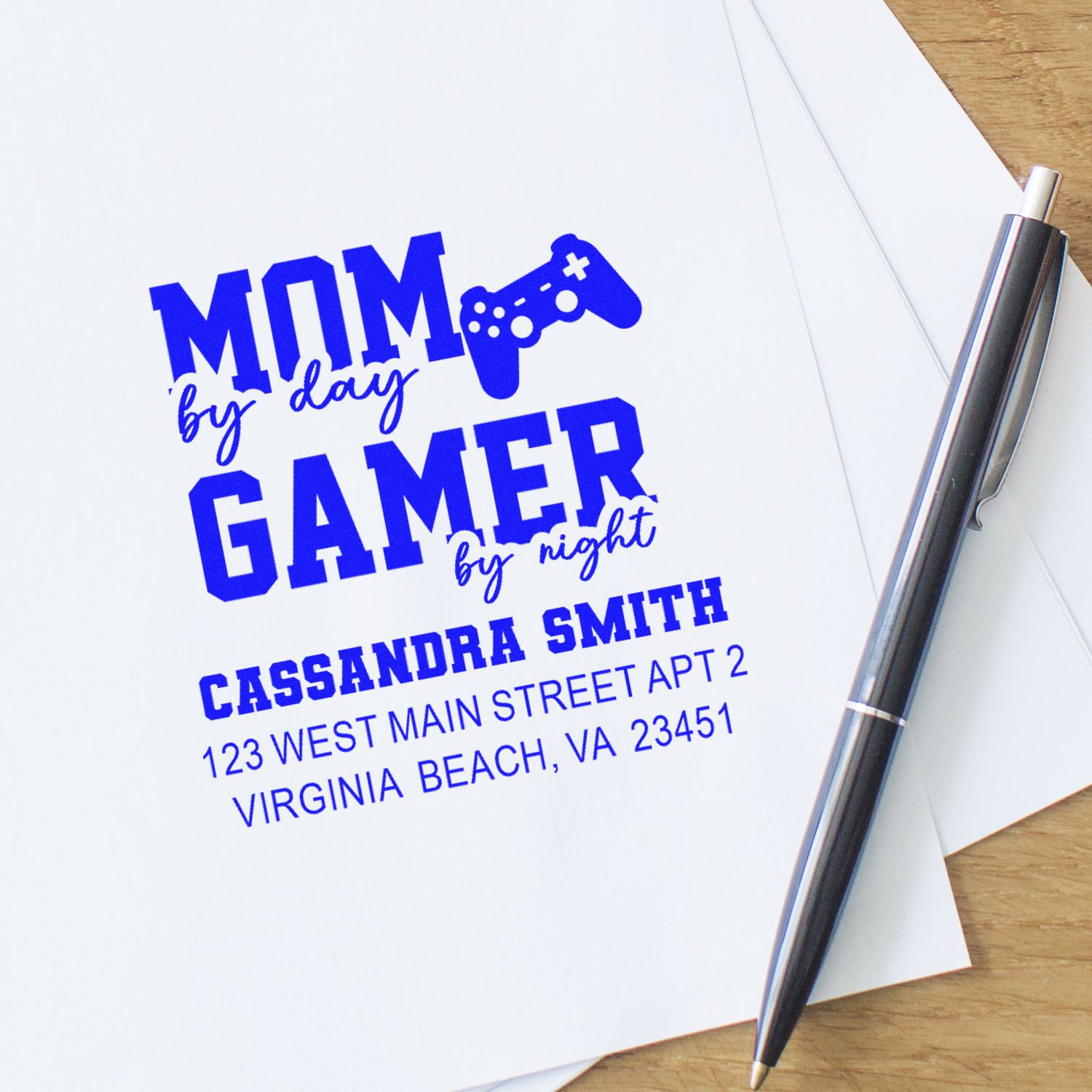 Personalized gamer mom rubber stamp with name and address in blue ink on paper, featuring Mom by day, Gamer by night design.