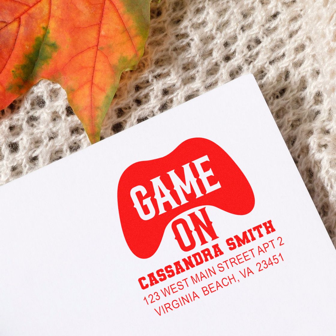Custom rubber stamp imprint with Game On controller logo and address, showing a personalized return address stamp on paper.