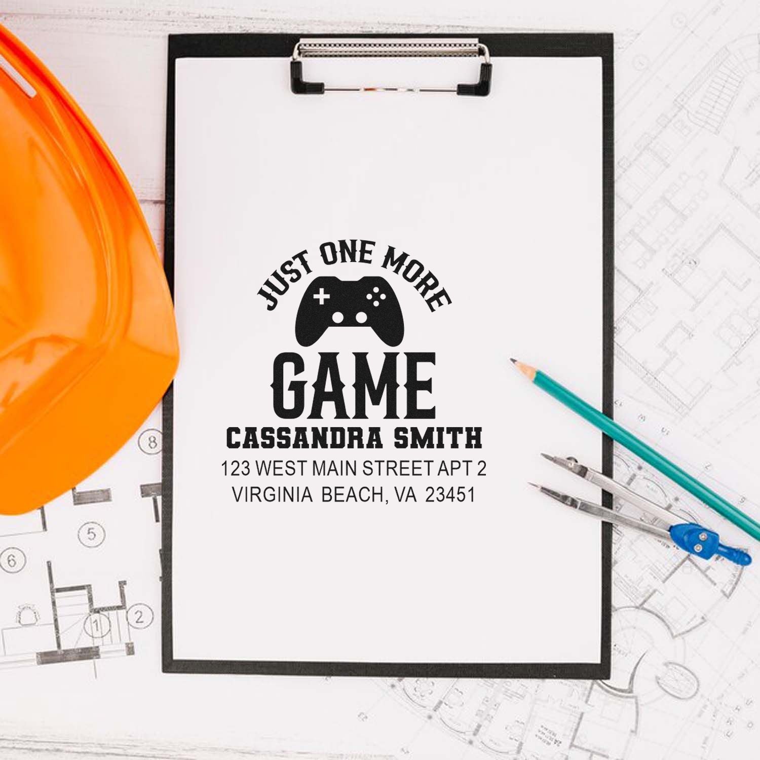Personalized rubber stamp with gamer controller logo, Just One More Game, and Cassandra Smith name and address.