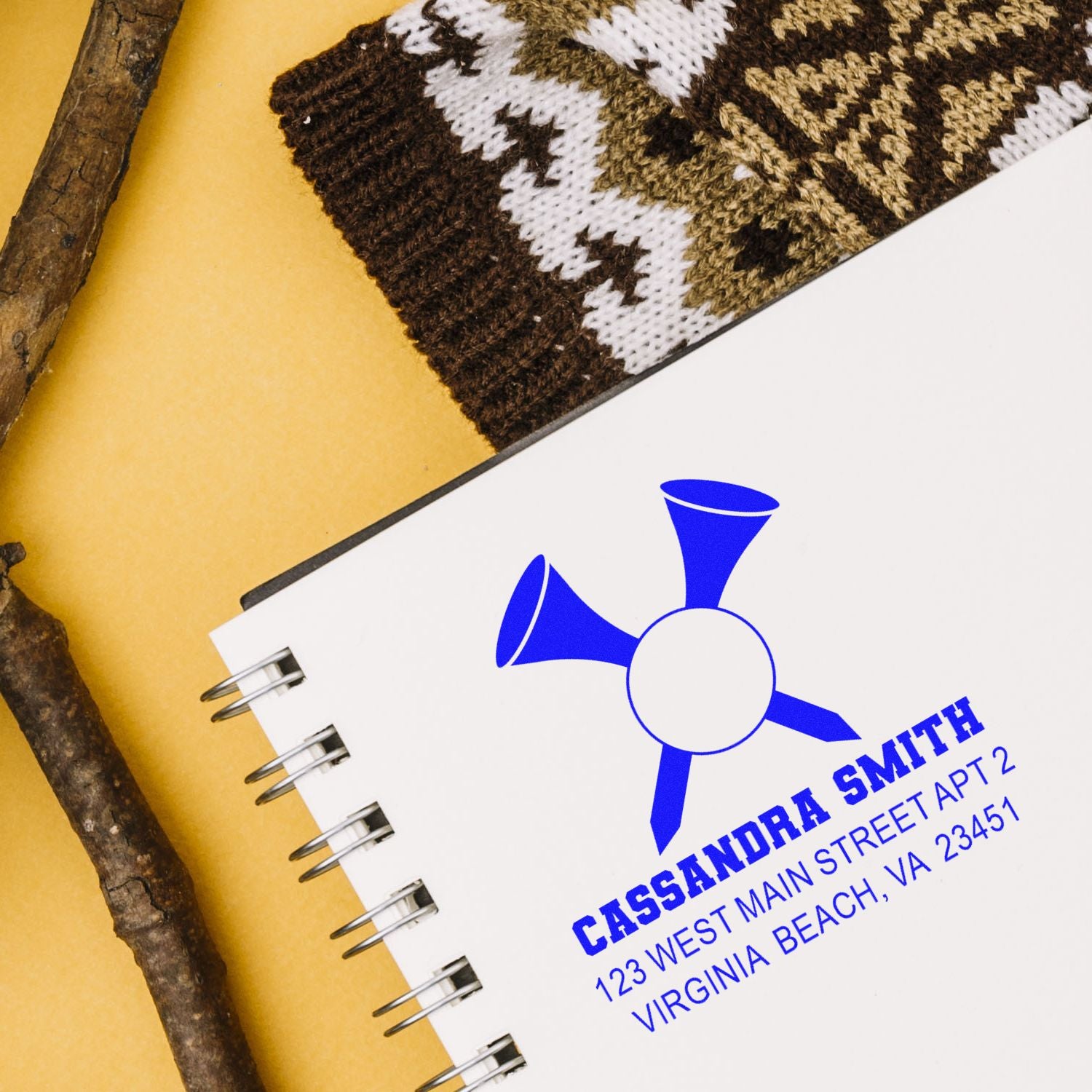 Custom rubber stamp logo with name and address on spiral notebook, ideal for personalized business branding.