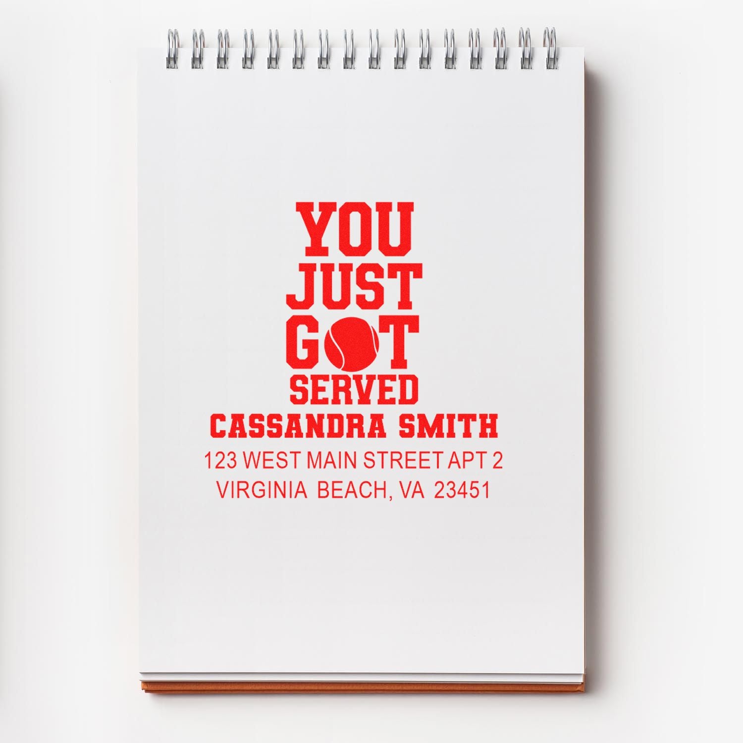 Custom tennis return address rubber stamp with You Just Got Served and personalized name and address on notebook.