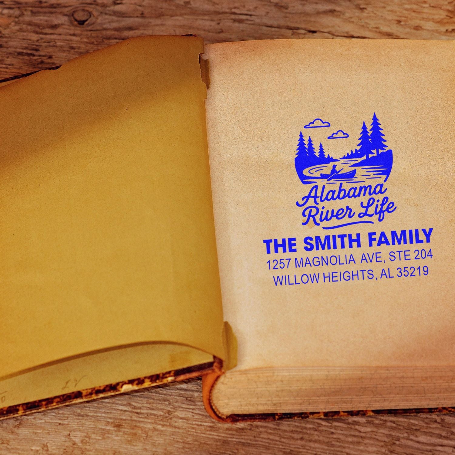 Custom logo address rubber stamp for The Smith Family, Alabama River Life, stamped in an open book.