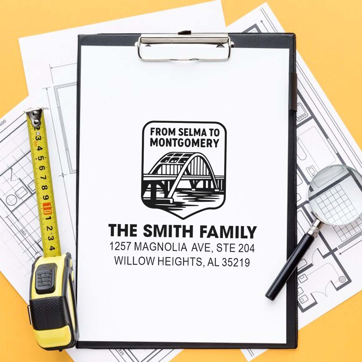Custom rubber address stamp for The Smith Family with bridge logo and return address on a clipboard.