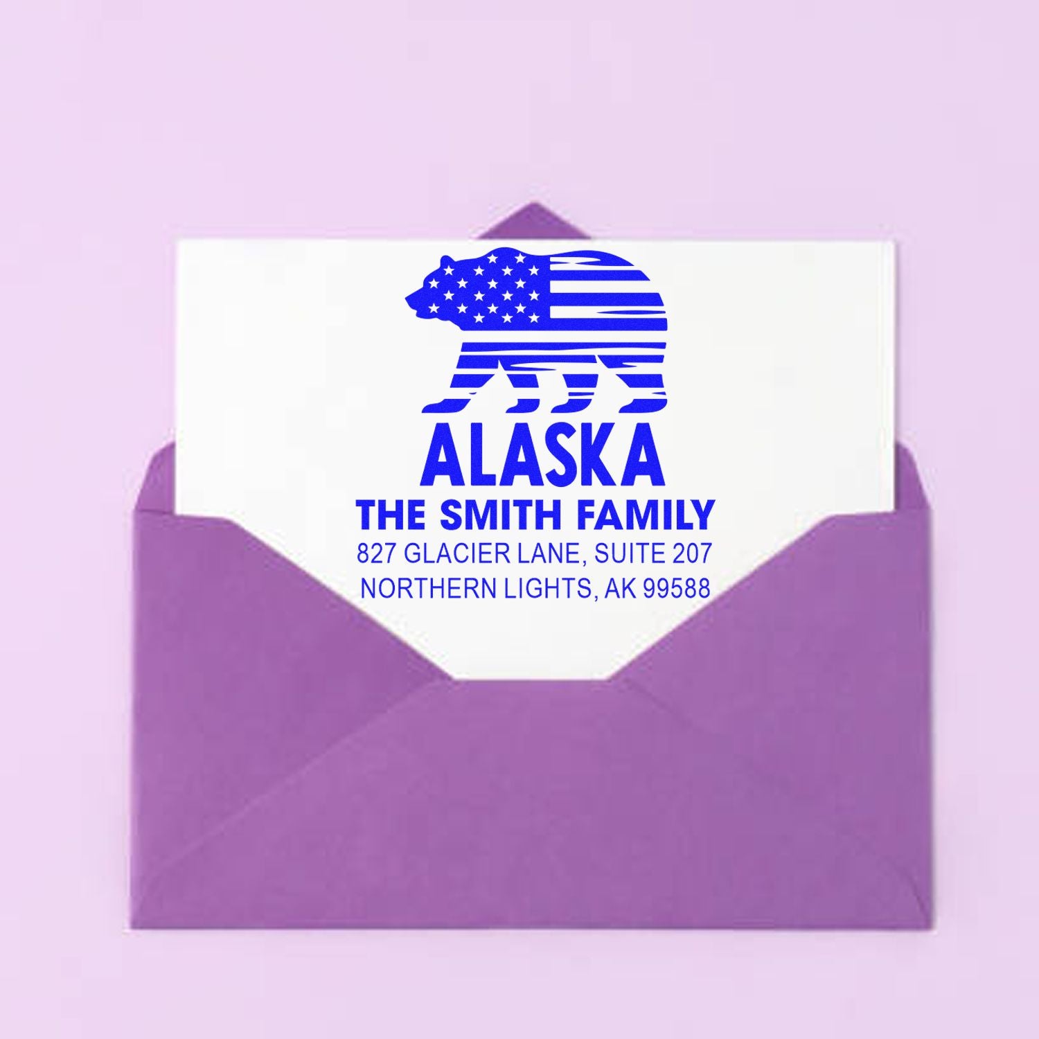Personalized Alaska return address rubber stamp with bear flag design on a purple envelope for family mailings.