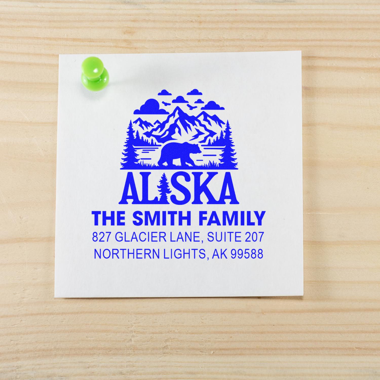 Custom Alaska address rubber stamp for The Smith Family with mountain, bear and pine design on paper.