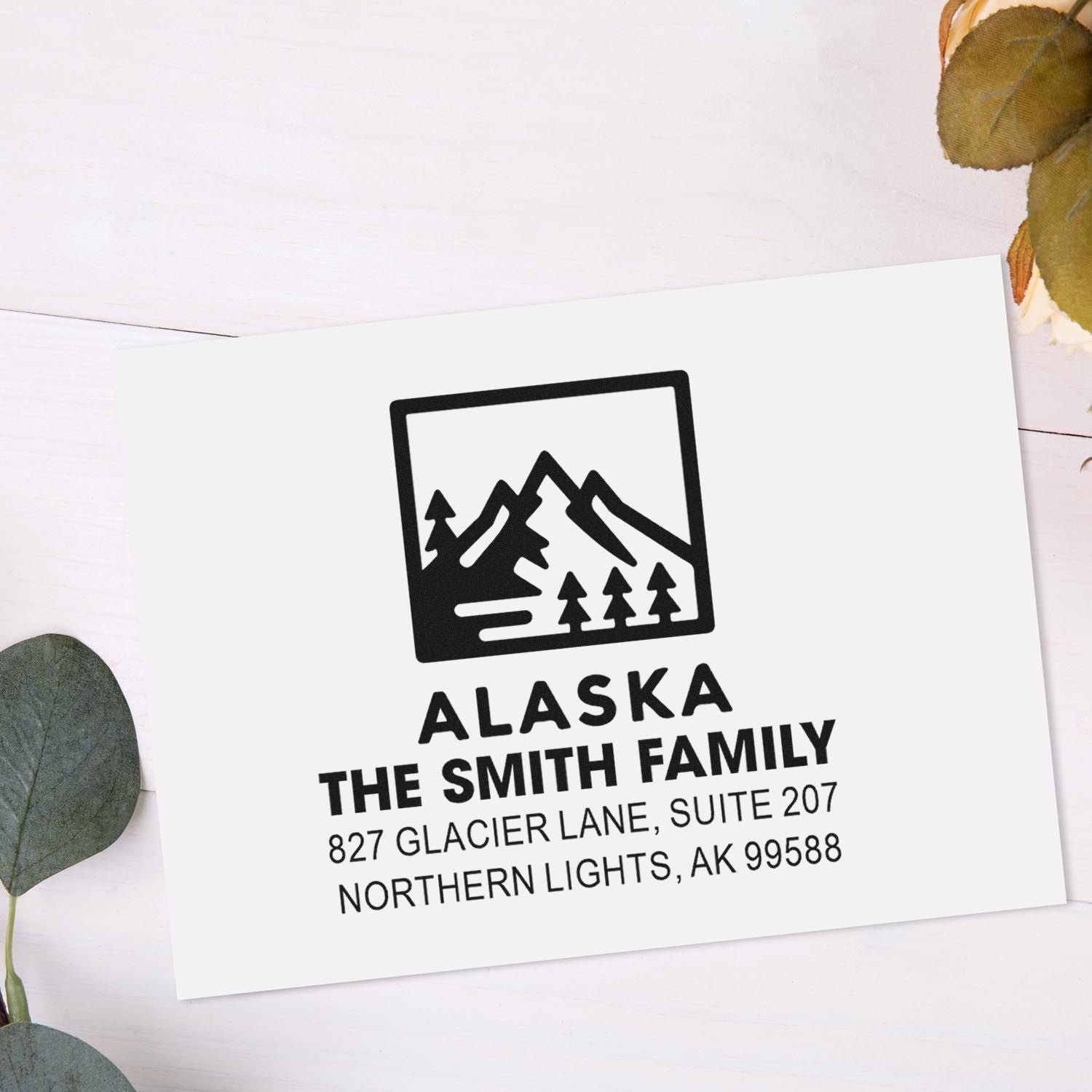 Custom Alaska address rubber stamp for The Smith Family with mountain logo and Northern Lights, AK return address.