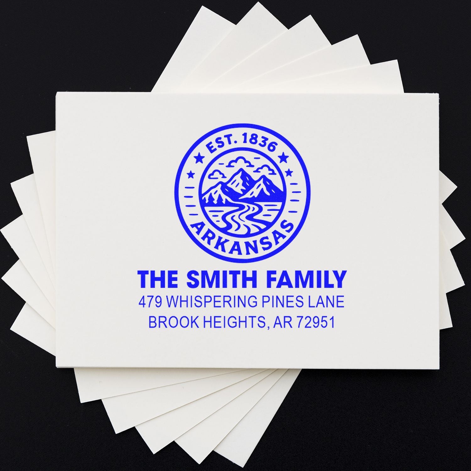 Custom address rubber stamp on stationery with Arkansas family name and mountain logo for personalized mailing.
