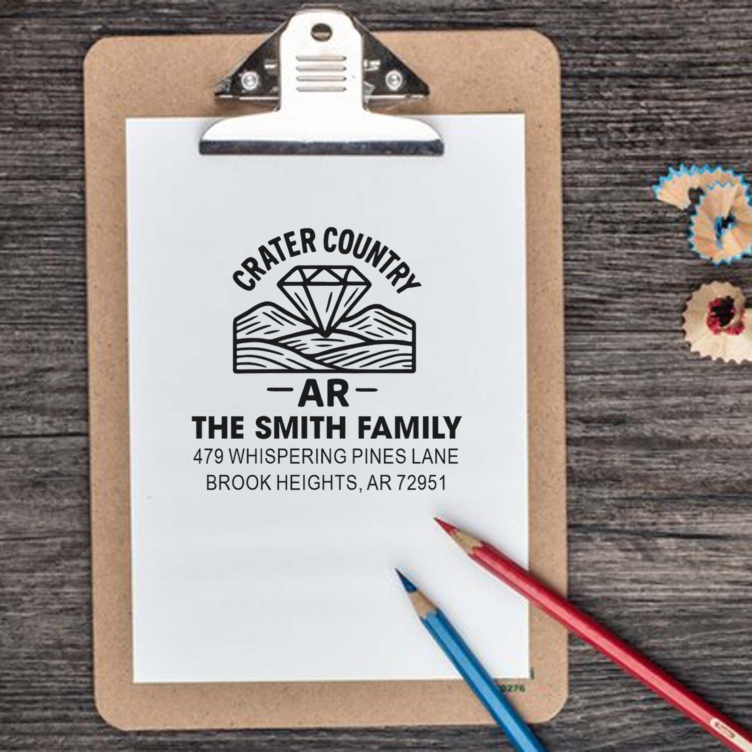 Custom return address rubber stamp design for The Smith Family in Crater Country, AR, shown on a clipboard.