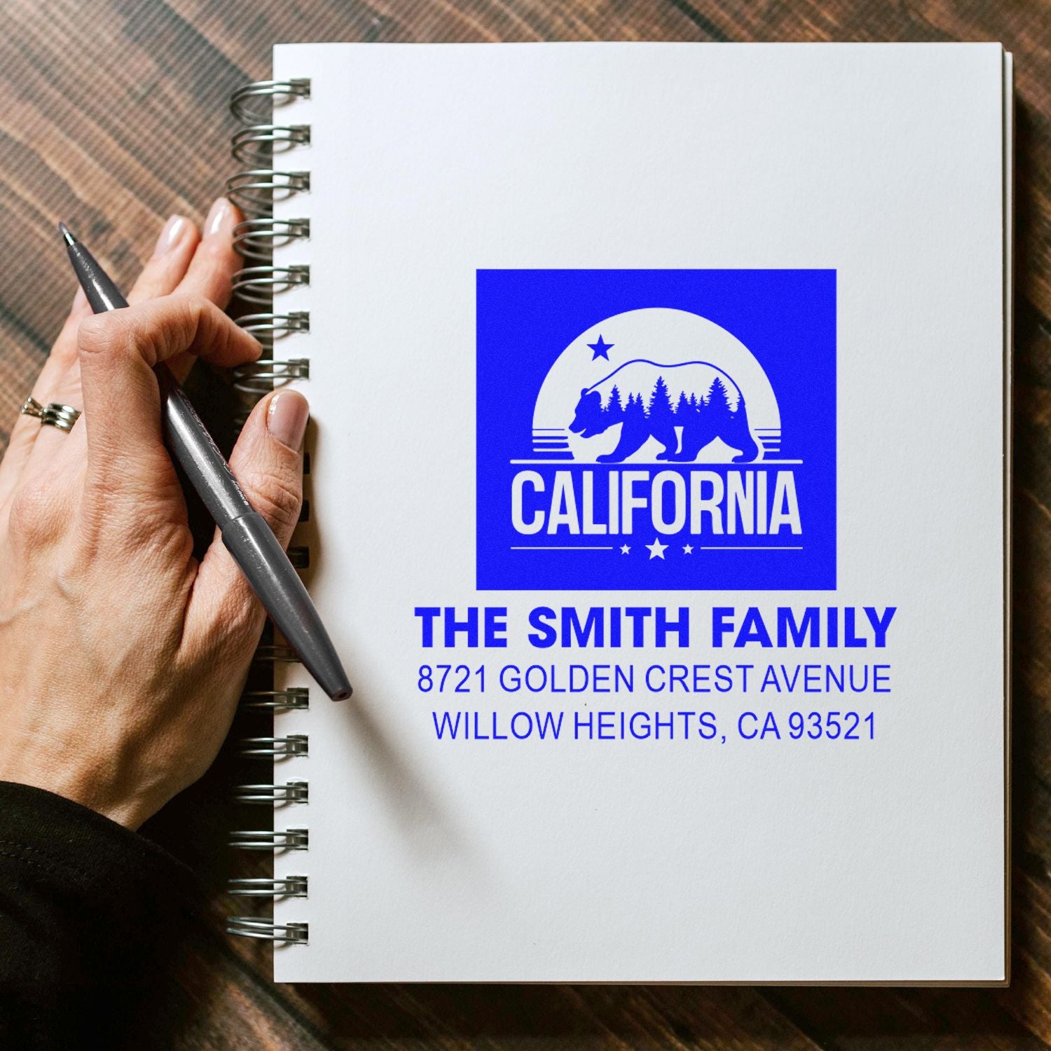 Custom rubber stamp impression for The Smith Family with California bear logo and return address on a notebook