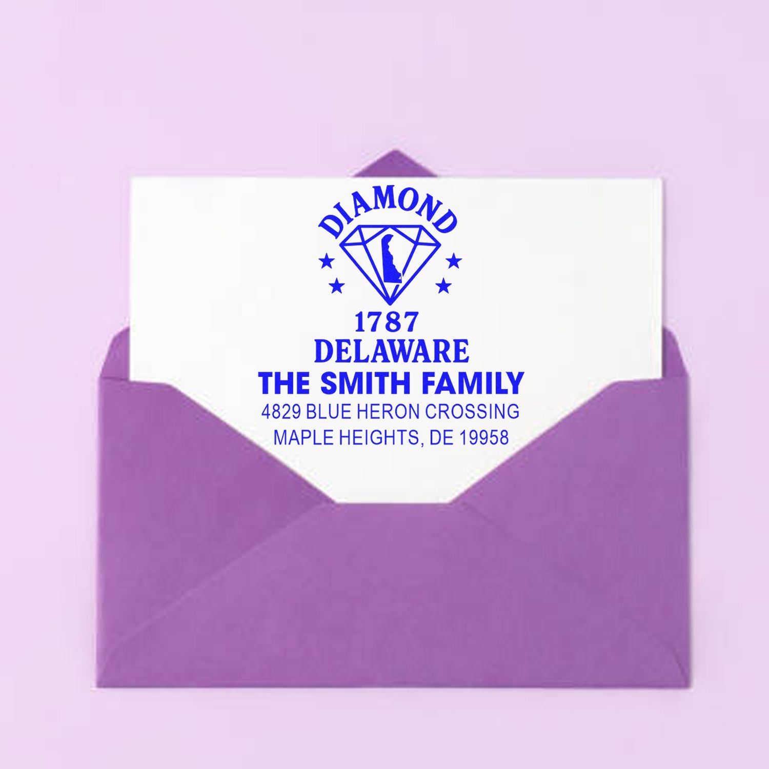 Custom return address rubber stamp for The Smith Family with Diamond Delaware 1787 design on a purple envelope.