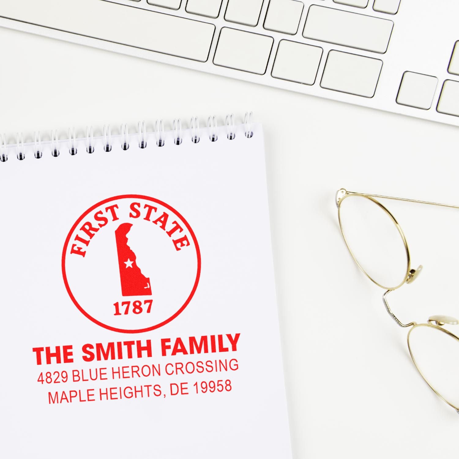 Custom family rubber stamp with Delaware First State icon, The Smith Family name, and address on a notebook page.