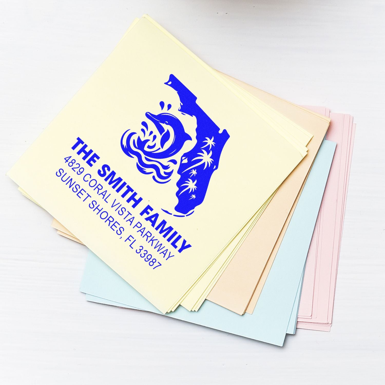 Custom rubber address stamp on pastel paper, featuring The Smith Family return address and coastal logo design.