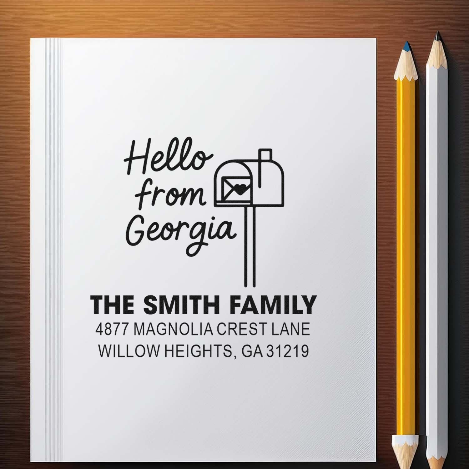 Personalized rubber stamp design with Hello from Georgia and The Smith Family return address on a notebook mockup.