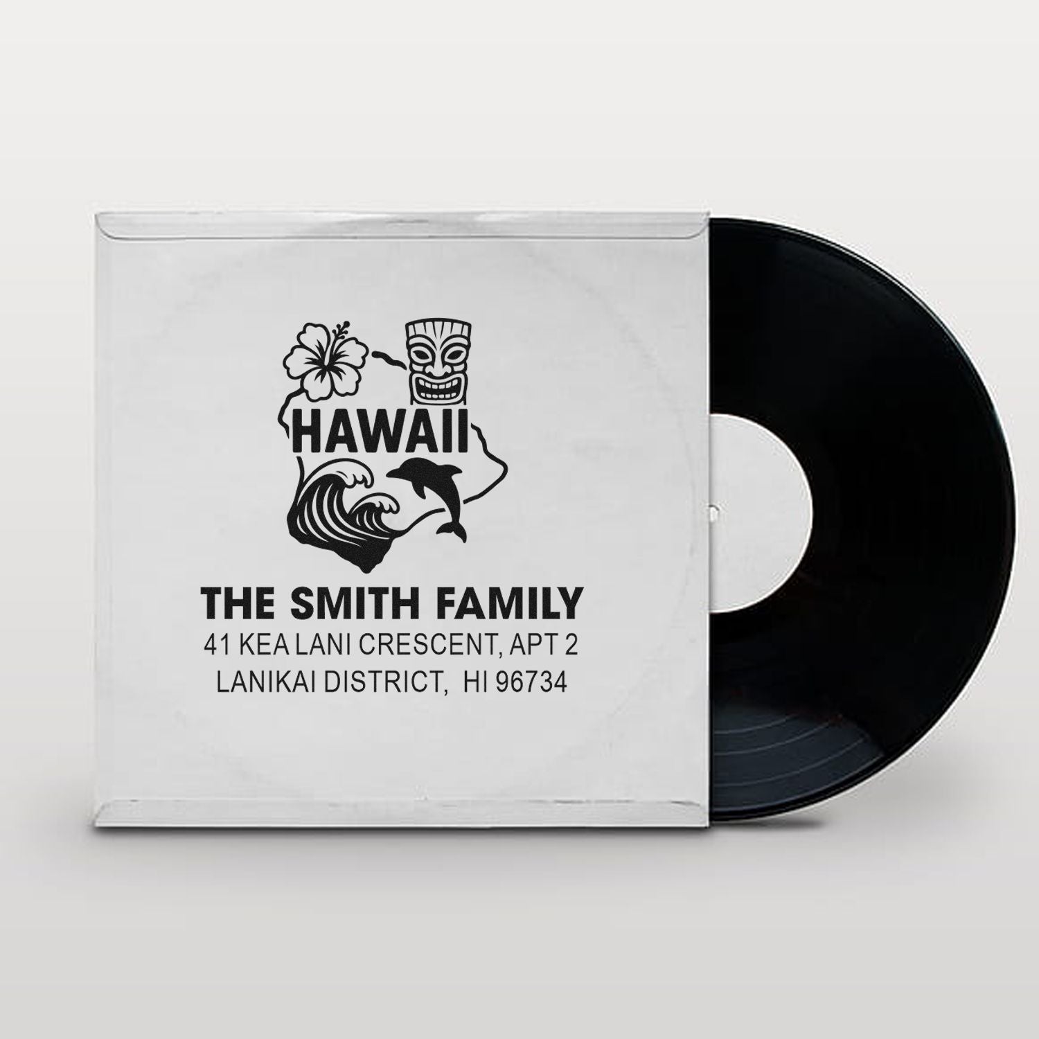 Personalized Hawaii return address rubber stamp with tiki, hibiscus, wave and dolphin, shown on a vinyl record sleeve mockup.