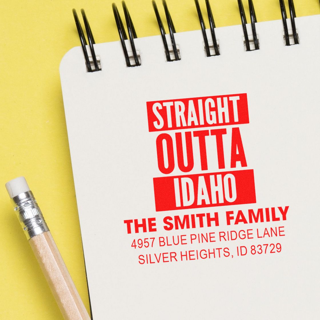 Personalized rubber address stamp reading Straight Outta Idaho with family name and Idaho return address on notebook.