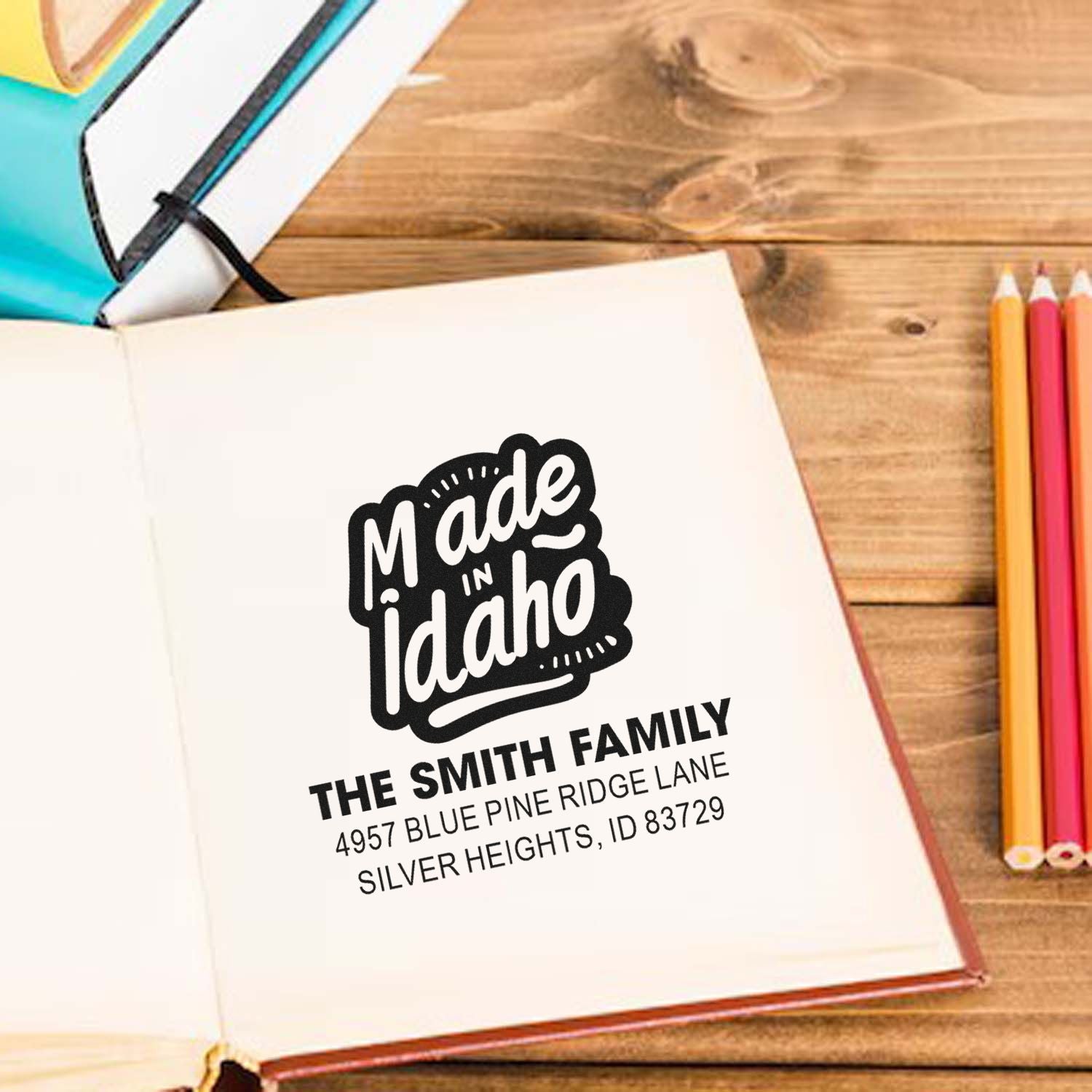 Personalized Made in Idaho return address rubber stamp mockup on an open notebook, styled on a wooden desk for custom branding.