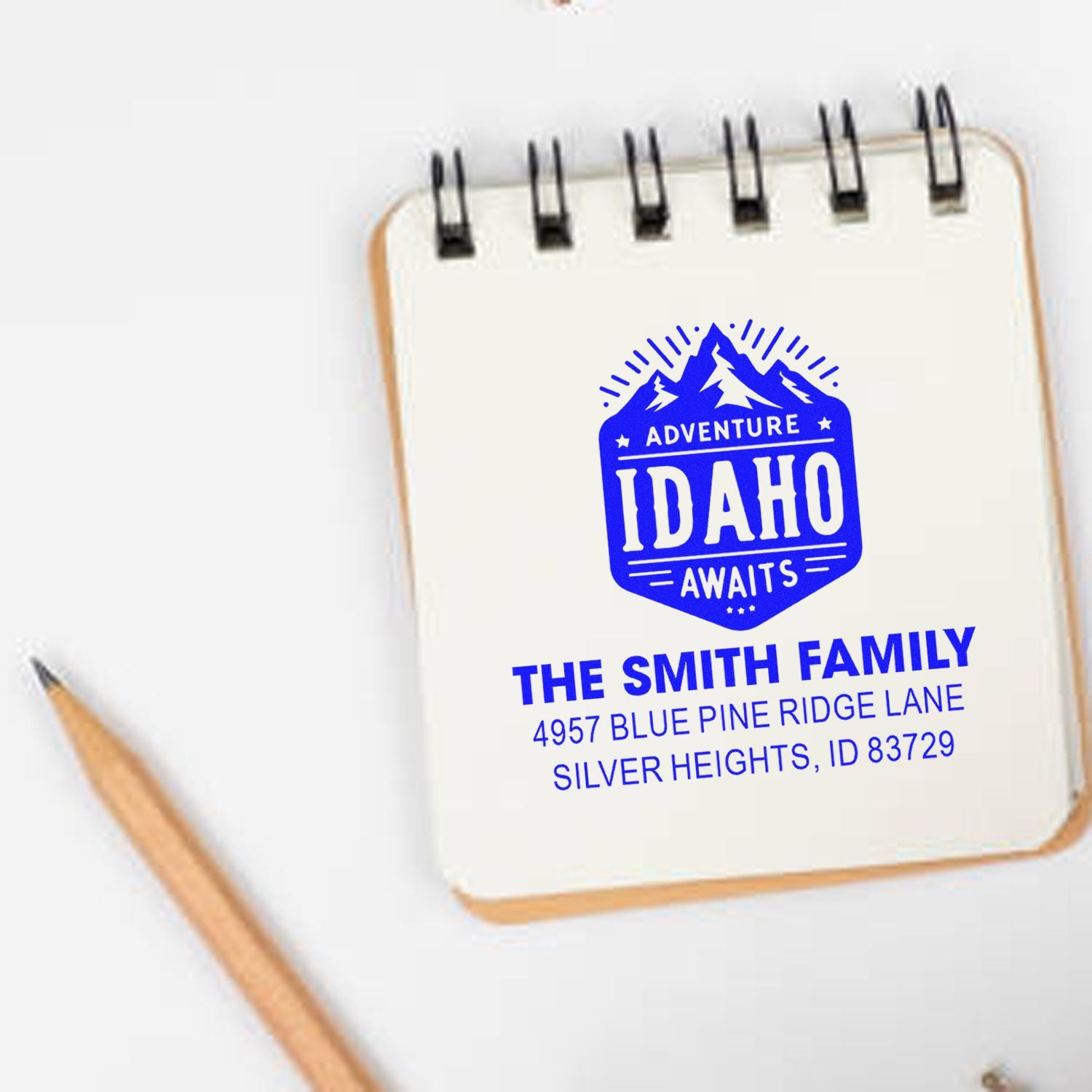 Custom Idaho adventure family address rubber stamp with mountain logo, shown on a notebook mockup.