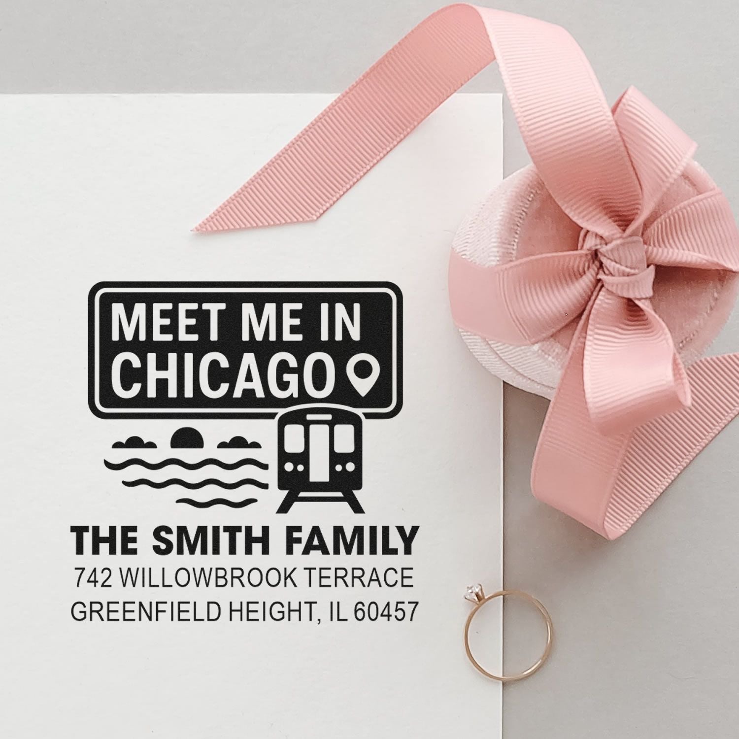 Personalized Chicago address rubber stamp with family name and return address, shown on a gift envelope with pink ribbon.
