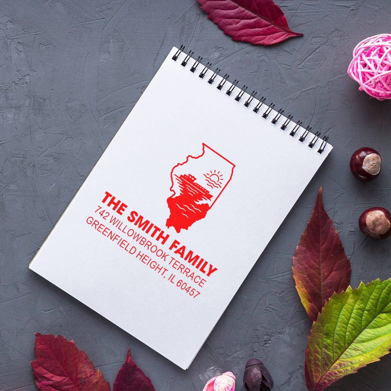 Custom return address rubber stamp with Illinois state logo on notebook, perfect for personalized mailing and craft projects.