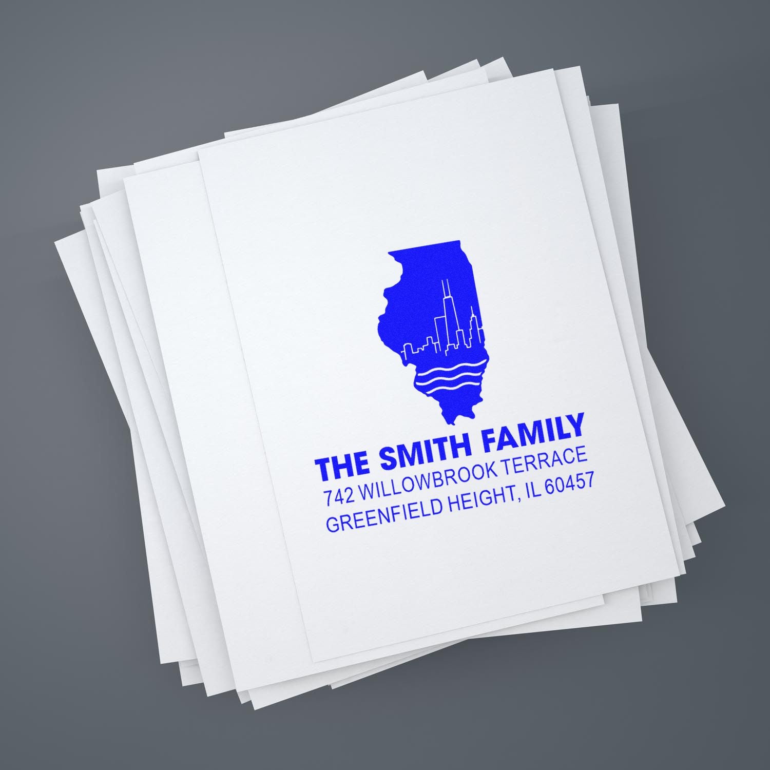 Custom rubber address stamp on paper stack featuring Illinois skyline and The Smith Family return address.