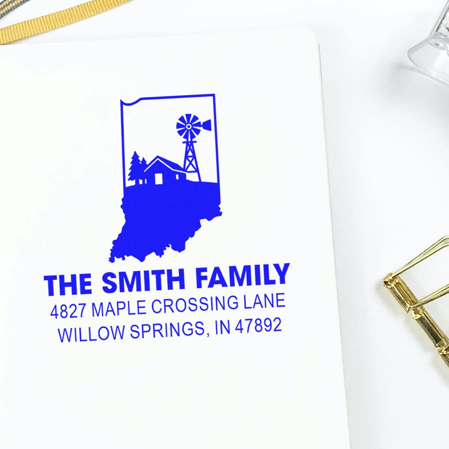 Personalized return address rubber stamp with Indiana state design, family name, and home address in blue ink