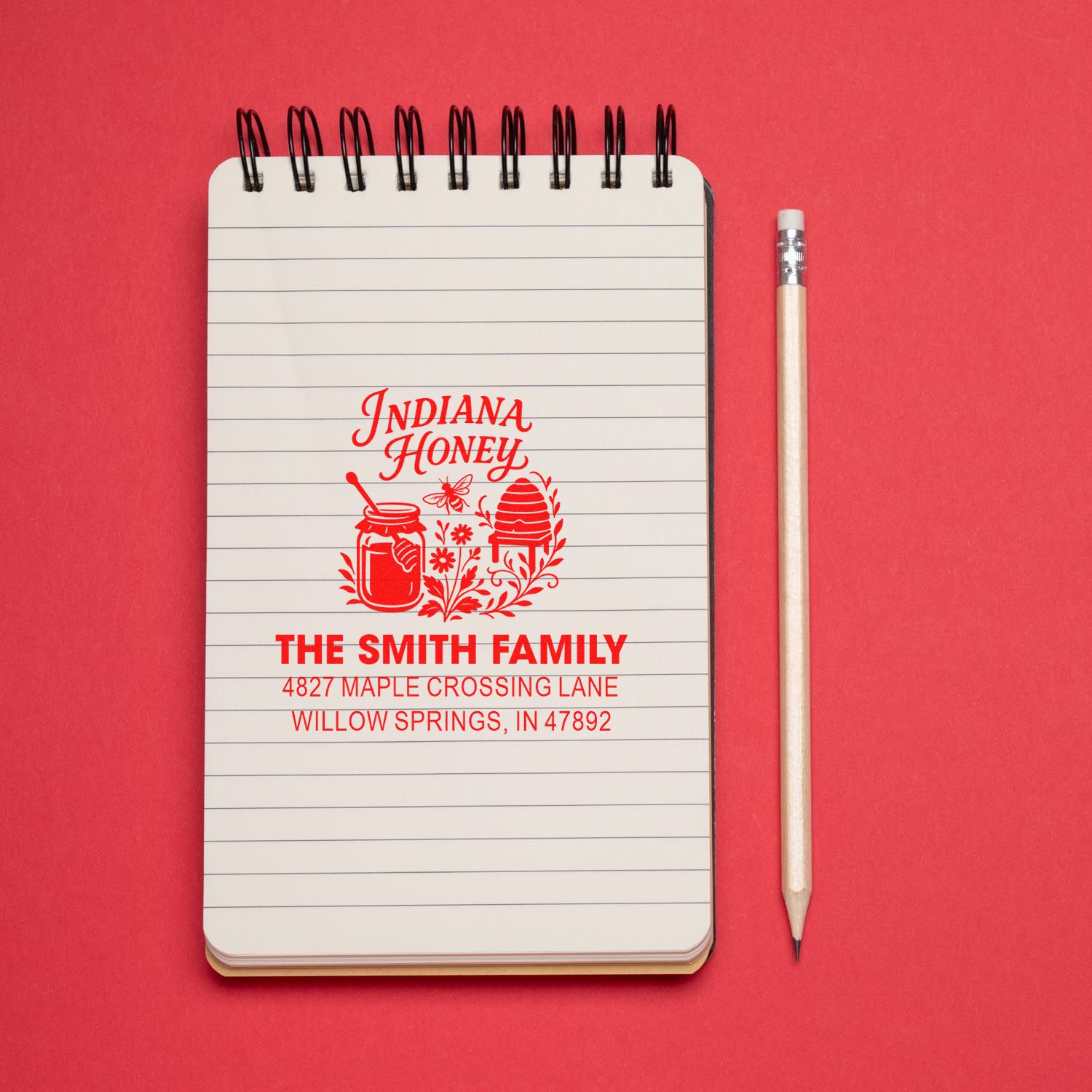 Custom honey bee return address rubber stamp for The Smith Family, with name and address on a notebook.