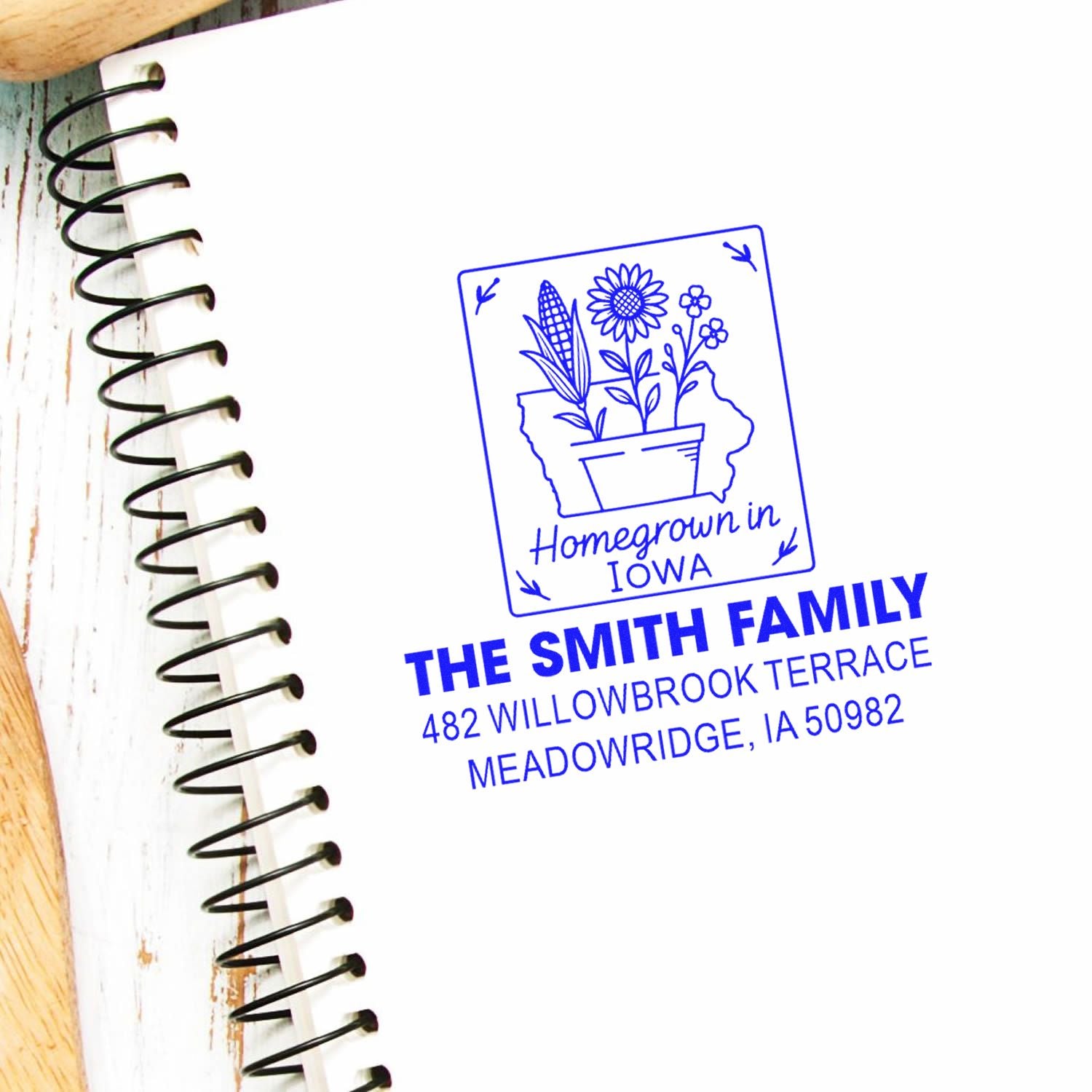 Custom rubber address stamp with Homegrown in Iowa design, Smith family name, and Meadowridge, IA address on a notebook.