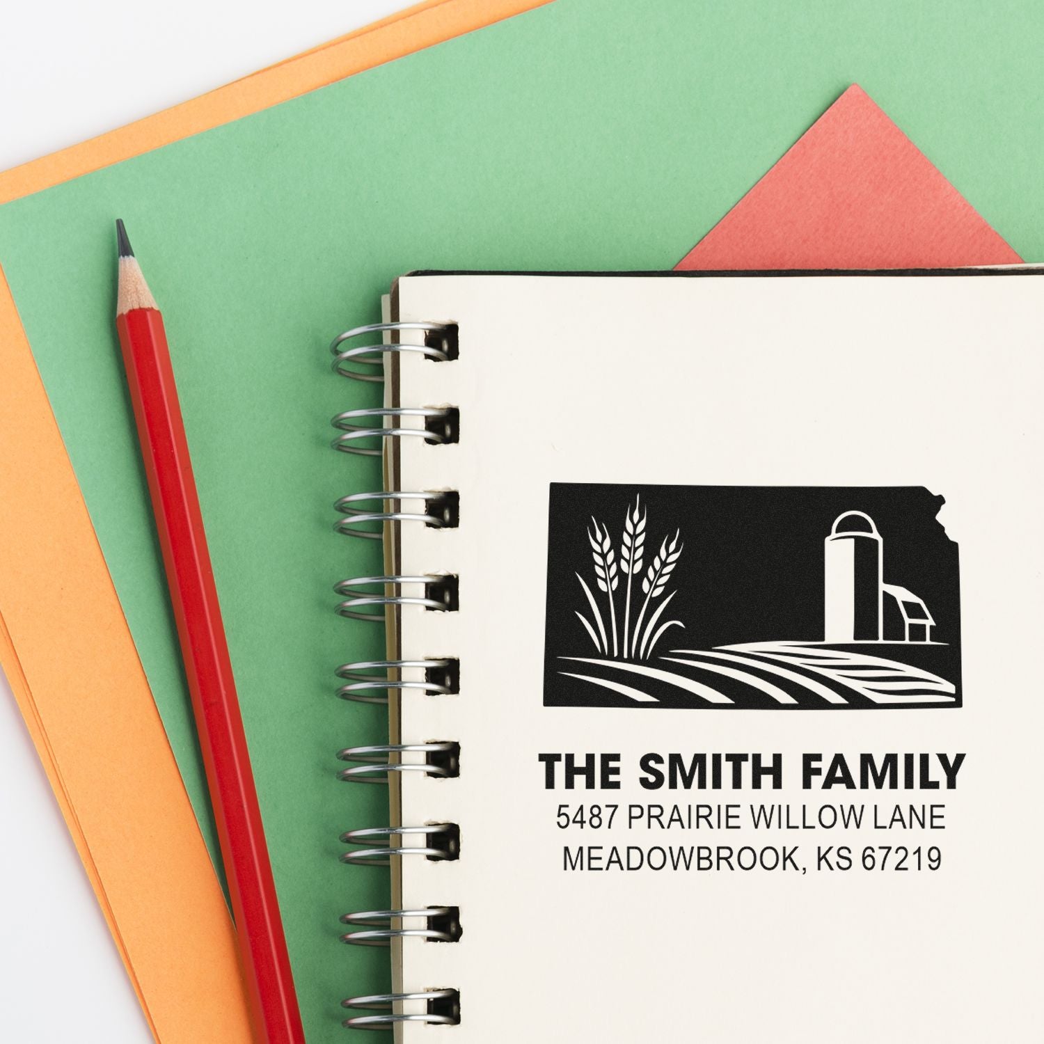 Personalized rubber address stamp with farm logo for The Smith Family, shown on a notebook with pencil and stationery.