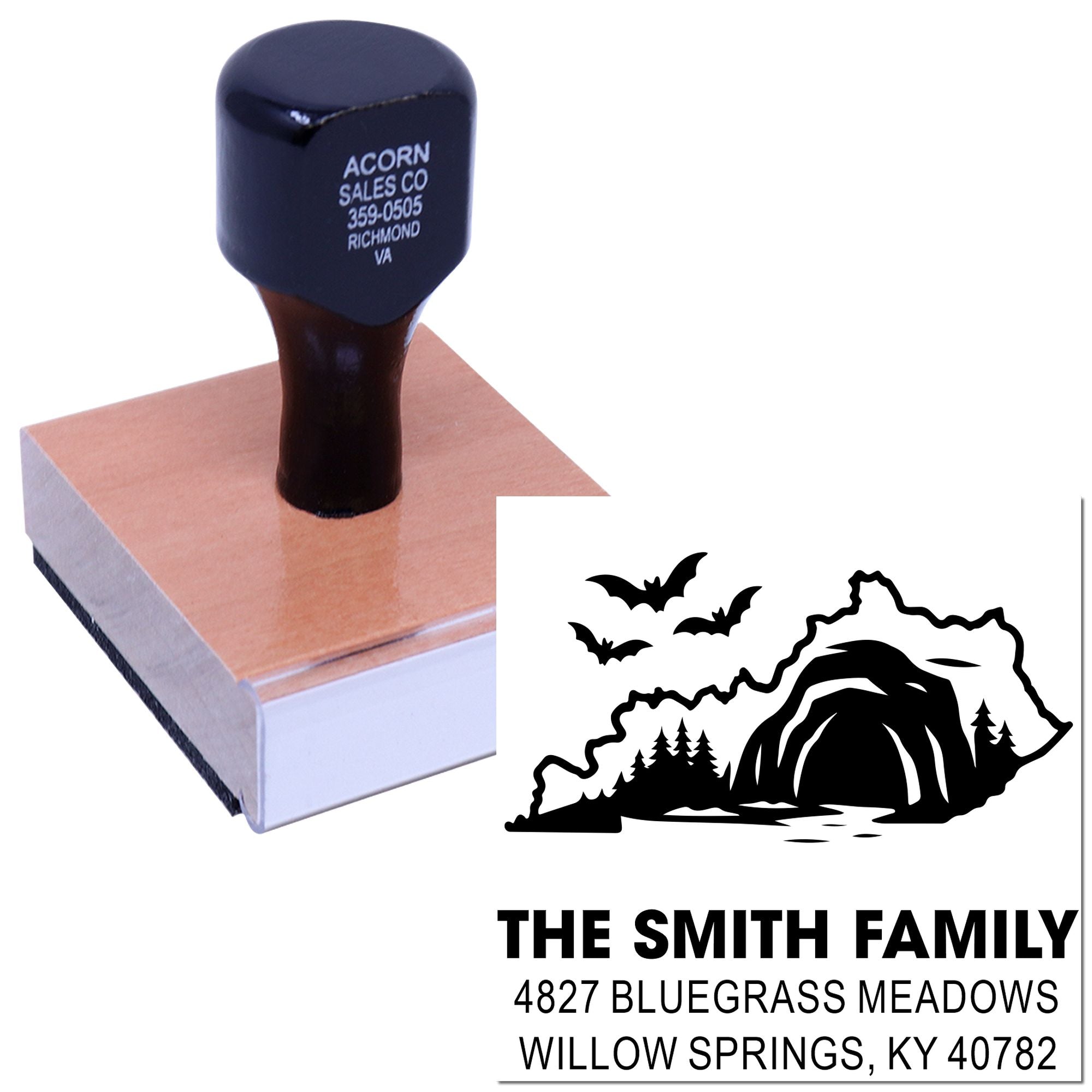 Personalized family address rubber stamp with cave and bats design, shown stamping a wood block with sample imprint.