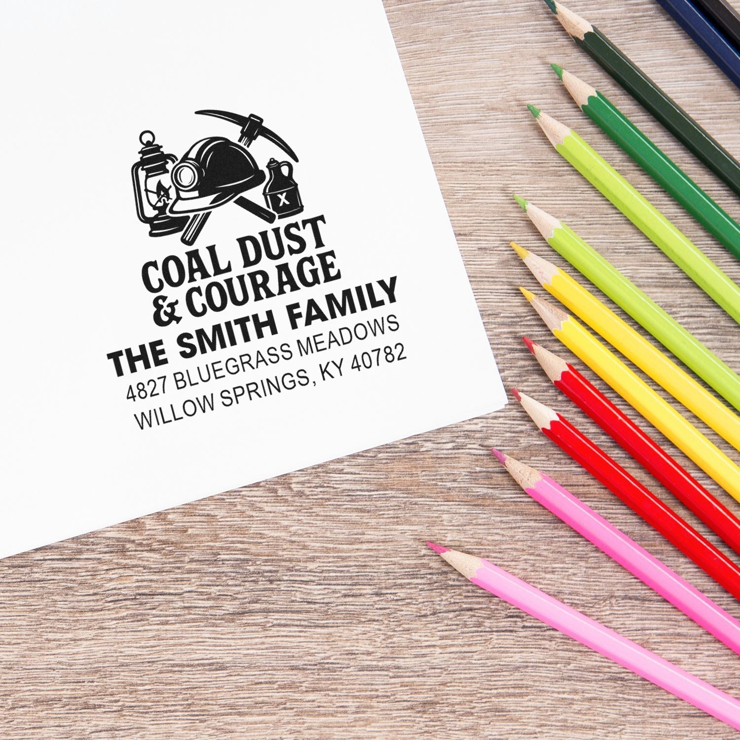 Personalized return address rubber stamp for a coal mining family, stamped on paper with colorful pencils.