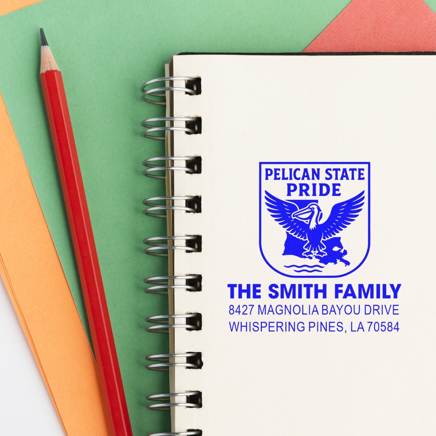 Custom rubber stamp with Pelican State Pride logo and return address for The Smith Family on a spiral notebook.
