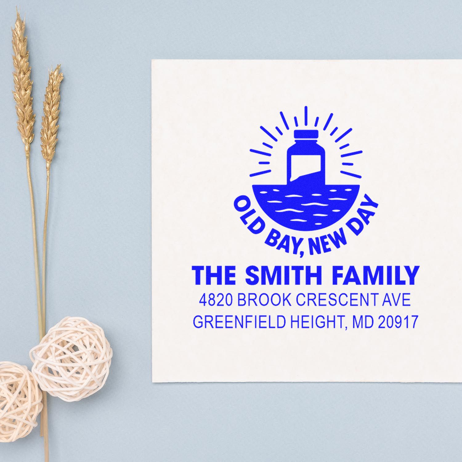 Custom return address rubber stamp for The Smith Family with Old Bay, New Day logo in blue ink.